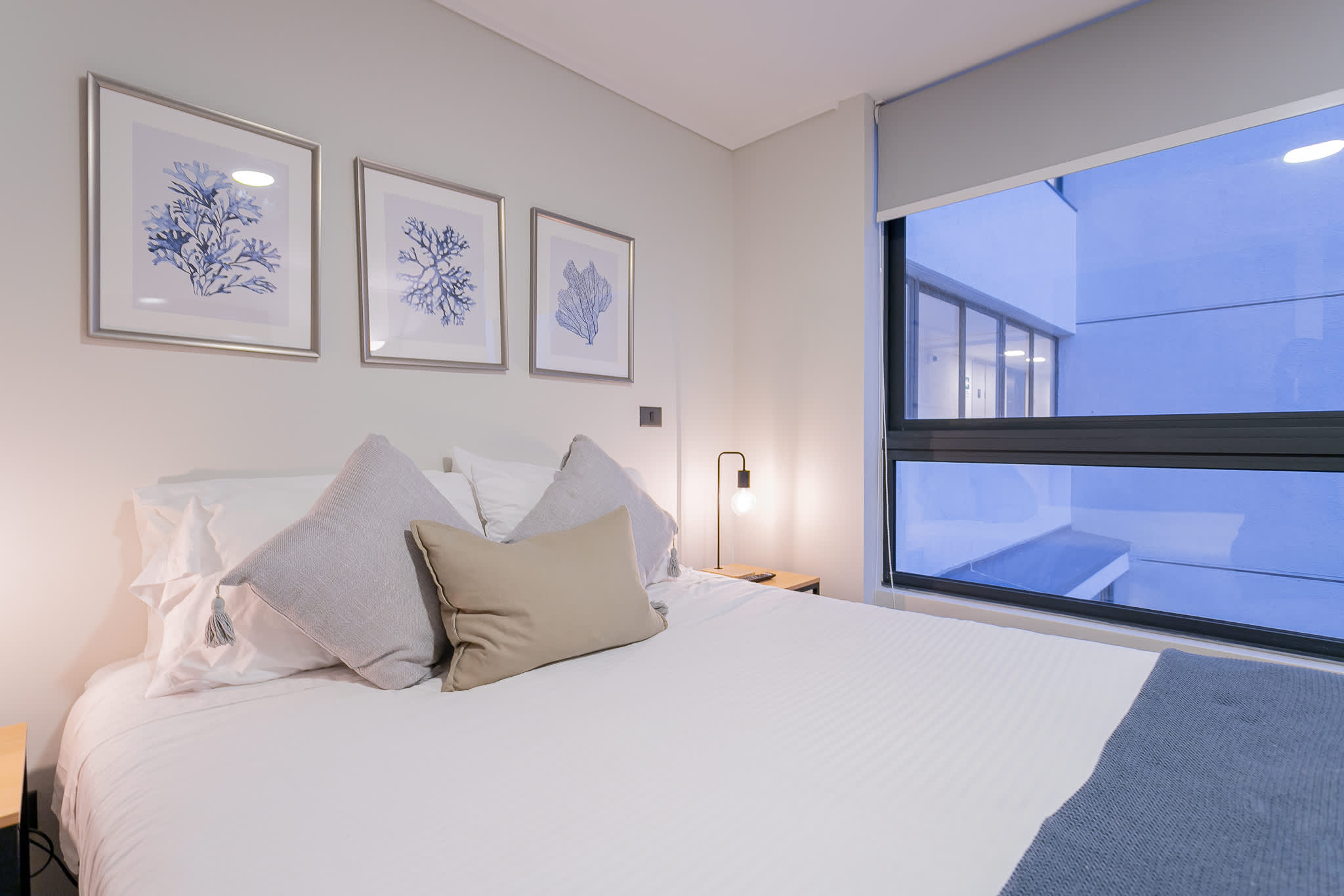 Relax in this cozy and stylish bedroom with modern decor and a large window offering natural light.