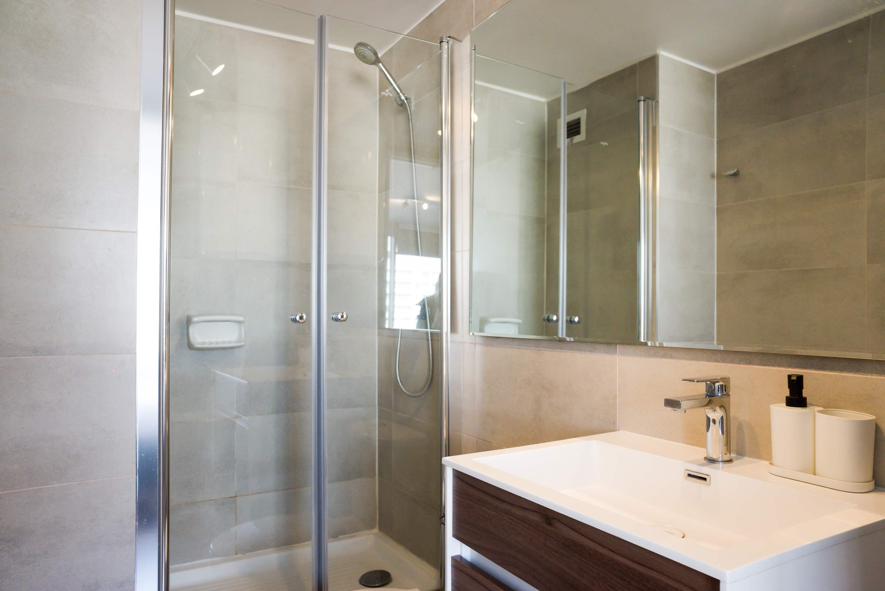Experience modern comfort in this sleek bathroom, featuring a spacious shower and contemporary design.