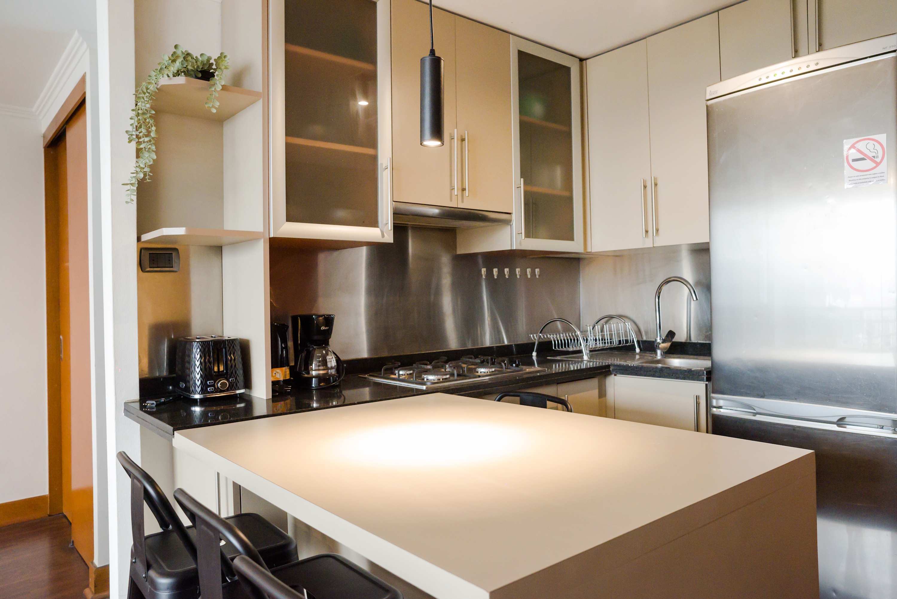 Sleek and modern kitchen with stainless steel appliances and cozy dining area, perfect for enjoying meals during your stay.