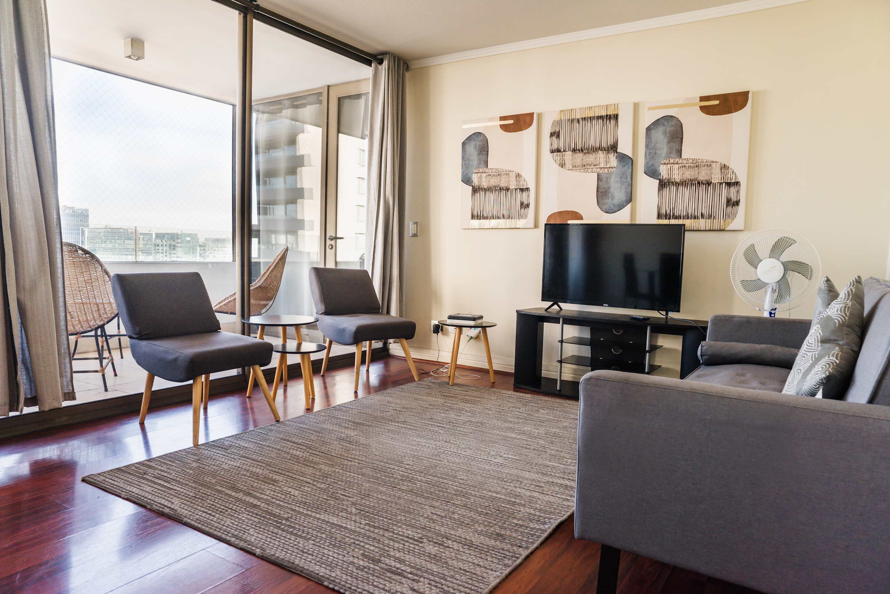 Relax in this stylish living room with a spacious balcony and city views, perfect for unwinding after a day of exploring.