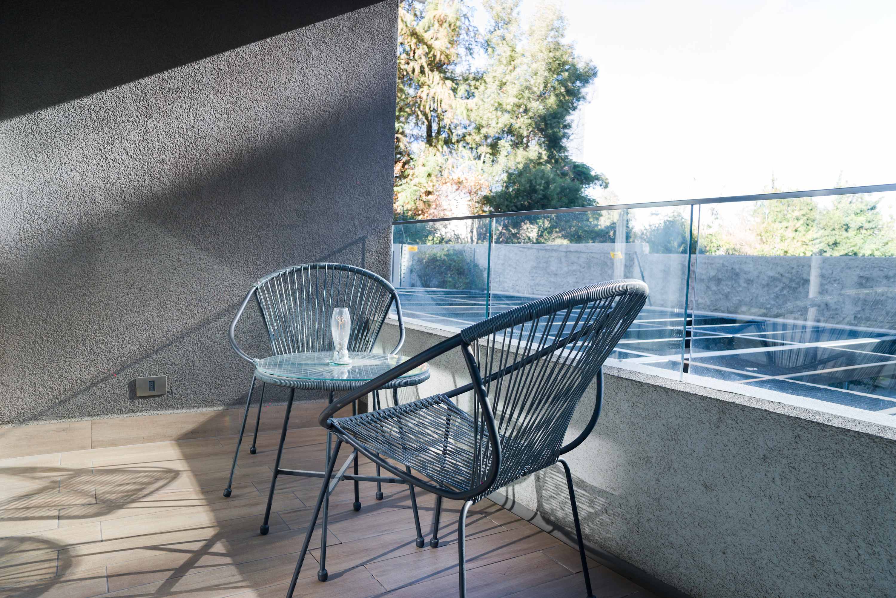 Relax on your private balcony with a refreshing drink and enjoy the serene view of lush greenery.