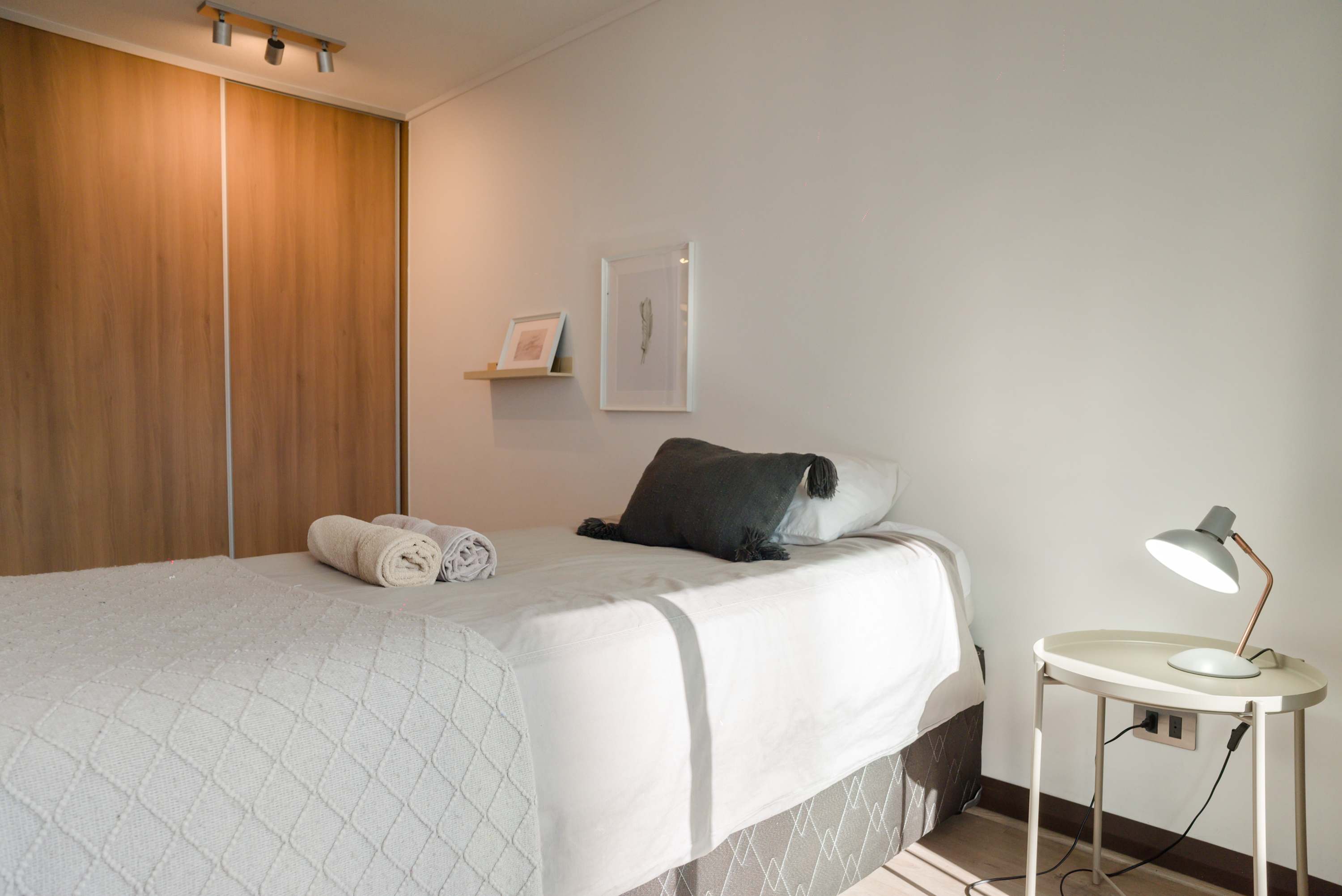 Relax in this cozy bedroom with modern decor and ample storage. Perfect for a restful stay.