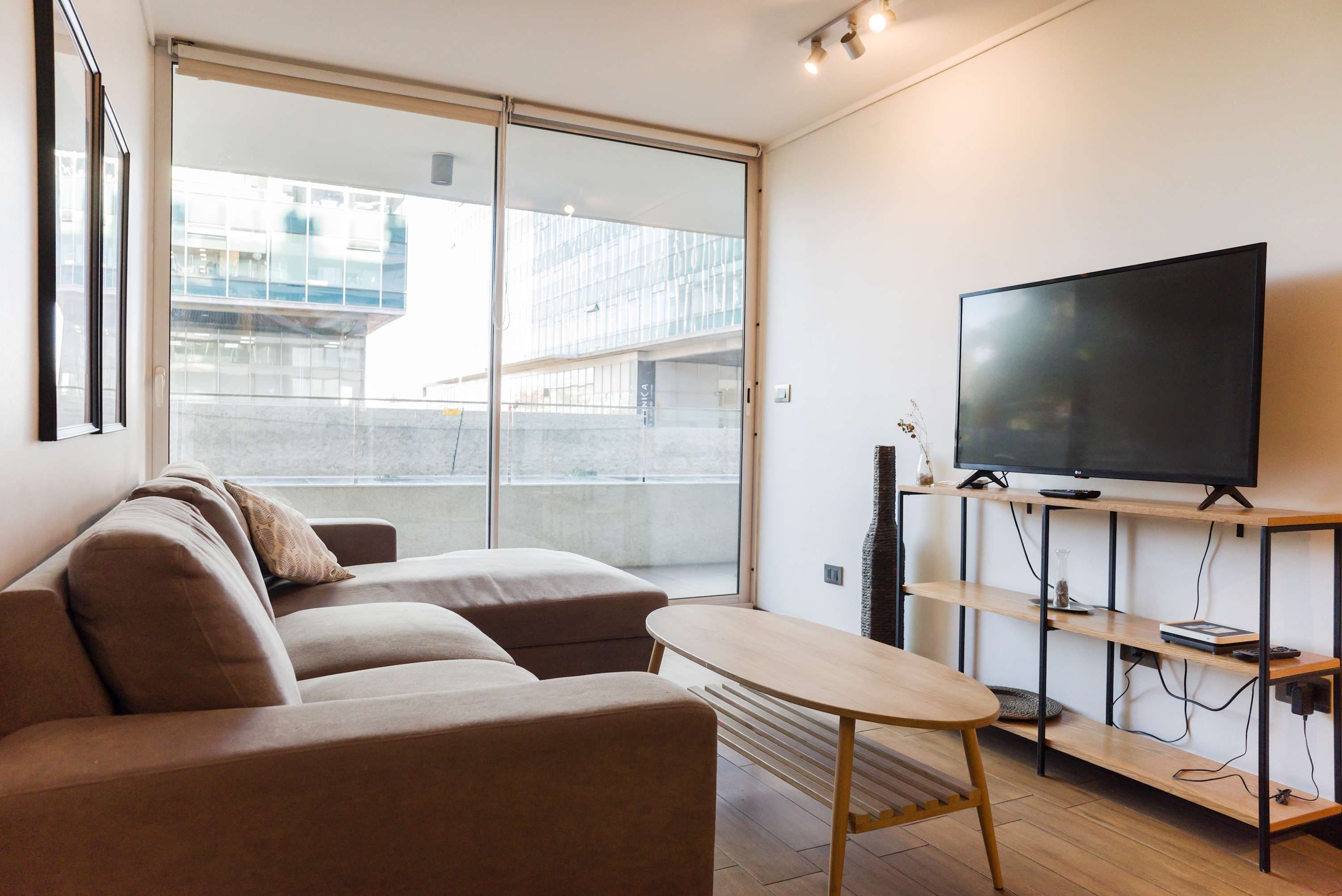 Relax in this bright and modern living room with a comfy sectional sofa and a large TV, perfect for unwinding after exploring the city.