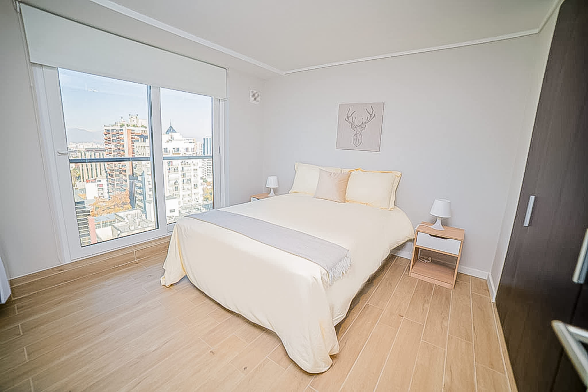 Relax in this bright, cozy bedroom with stunning city views and modern decor, perfect for a peaceful stay.