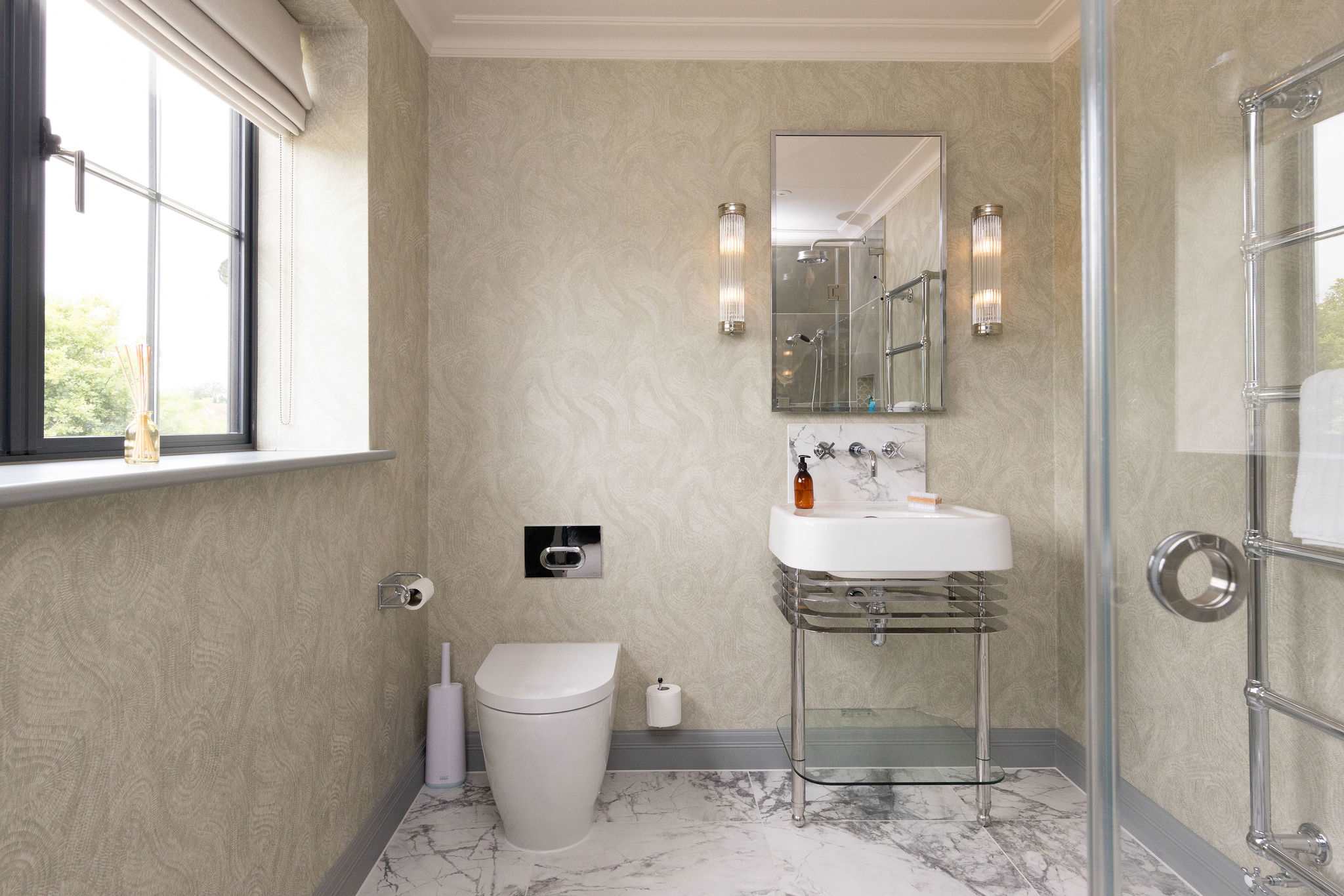 Beautiful bathroom with glass vanity and marble flooring