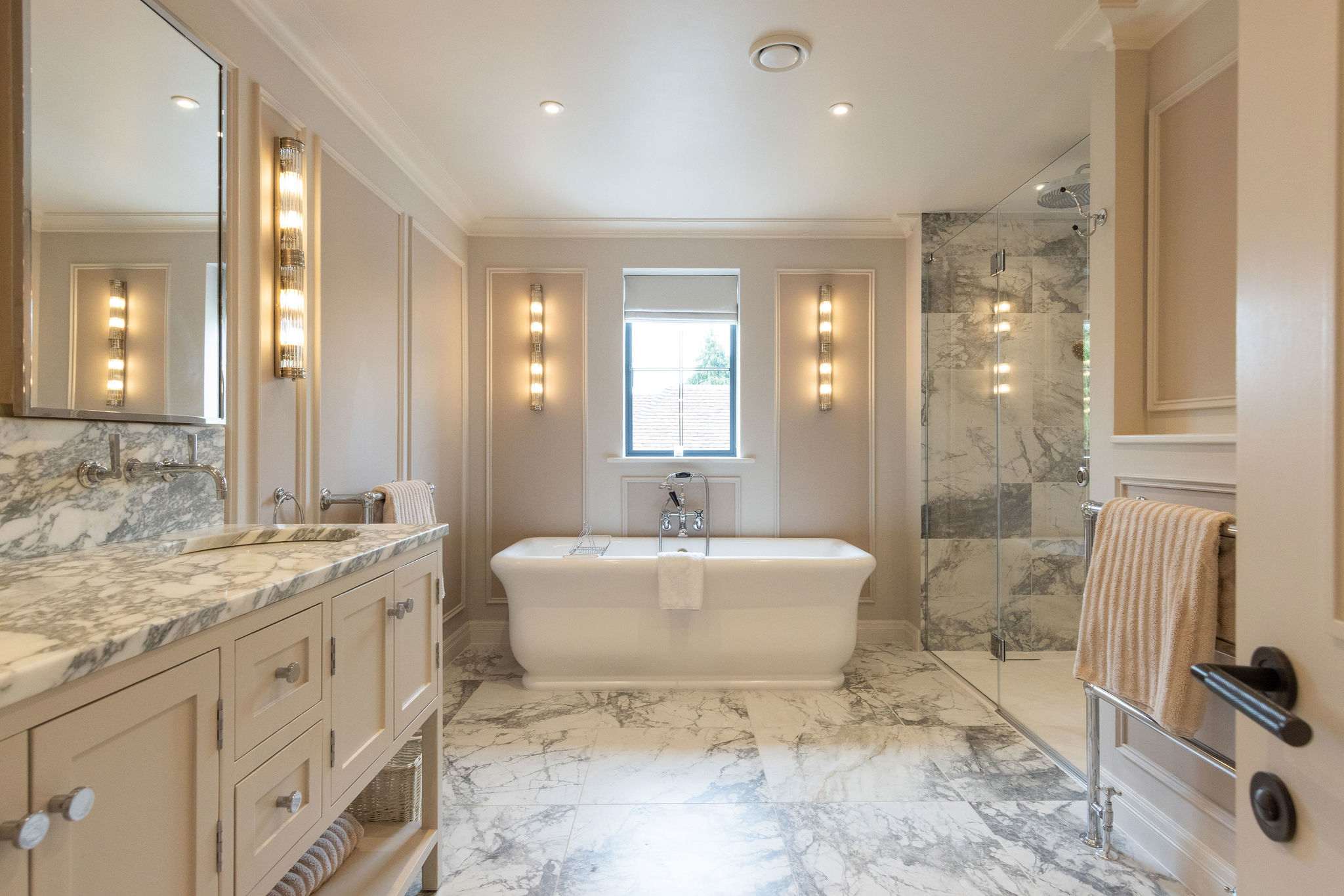 Soak in style in the marble-clad, spa-like en suite bathroom