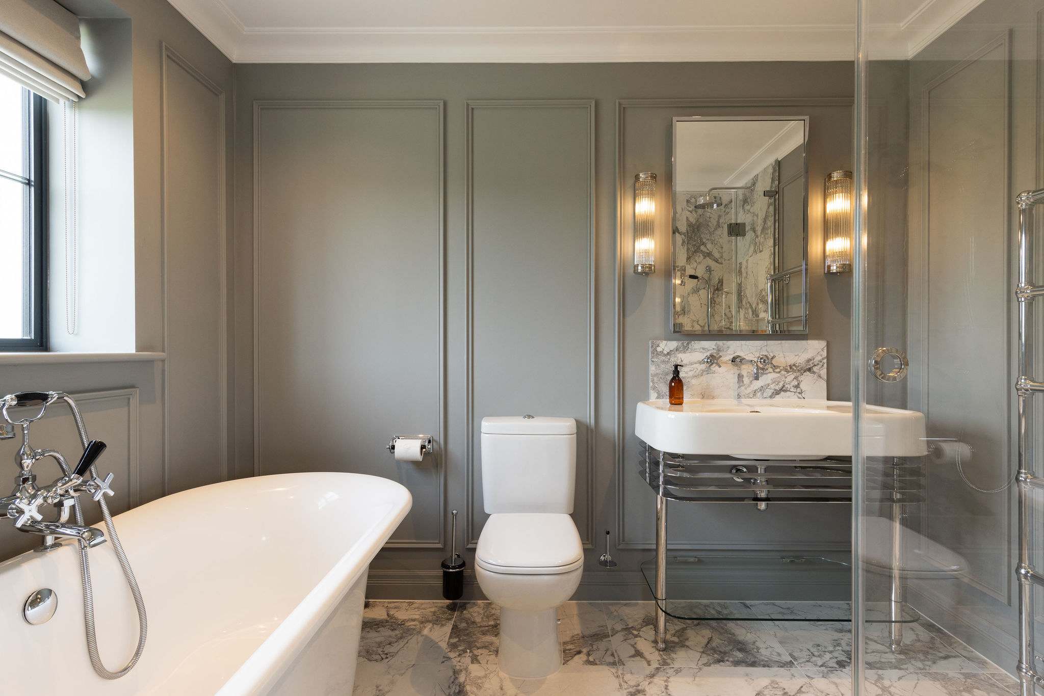 Elegant bathroom with marble flooring and panelled walls