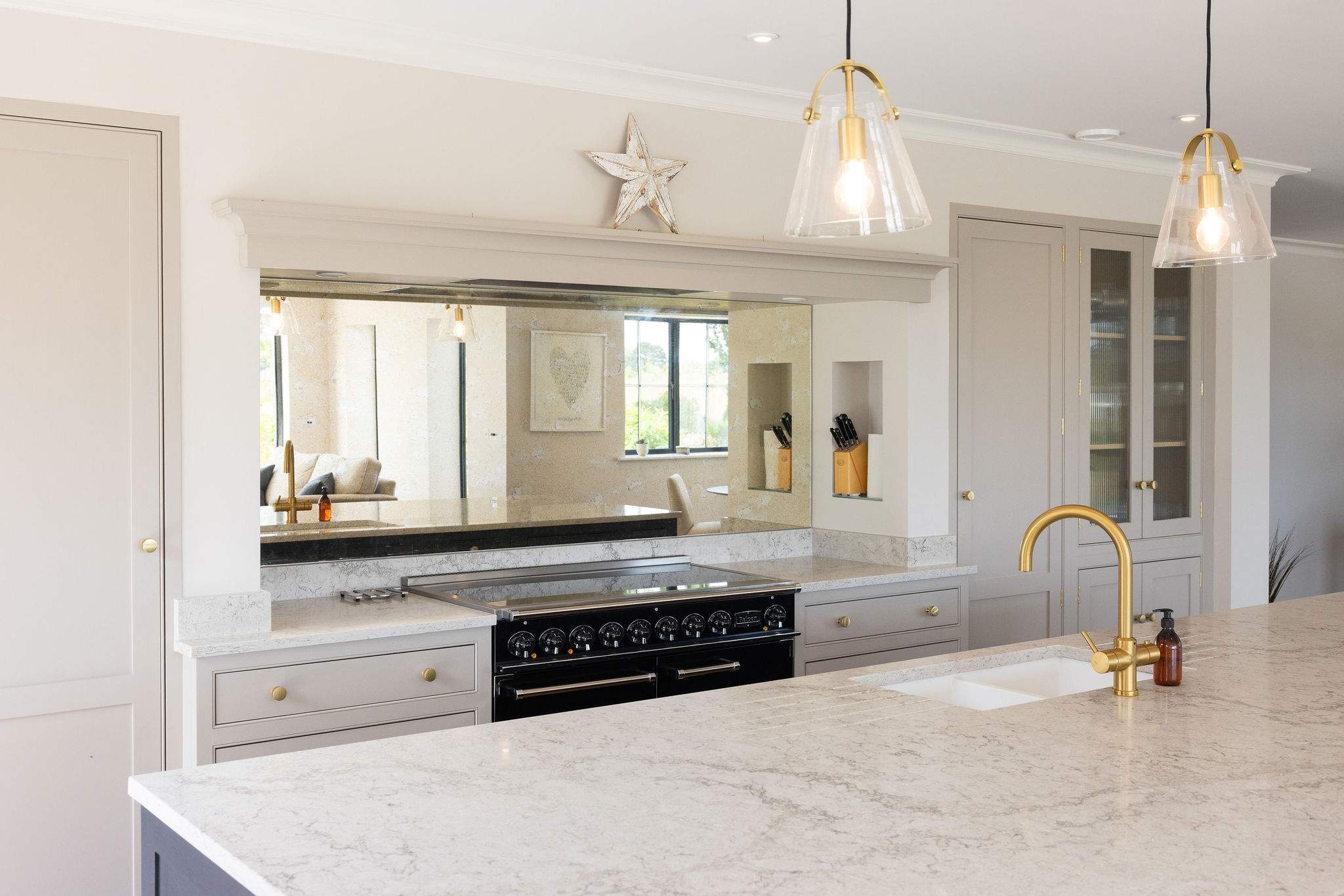 Sleek range and mirrored splashback in designer kitchen