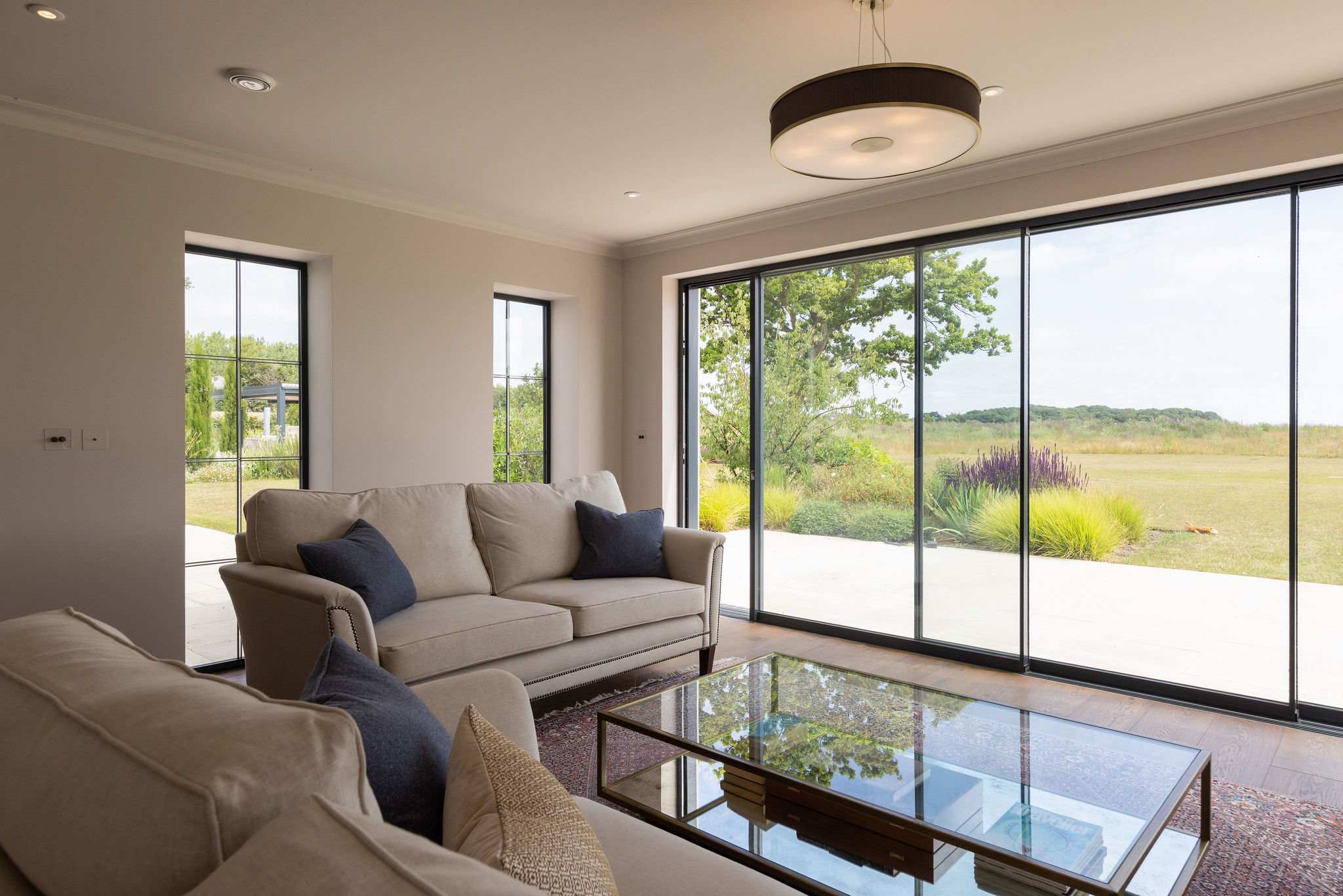 Large windows frame the peaceful countryside