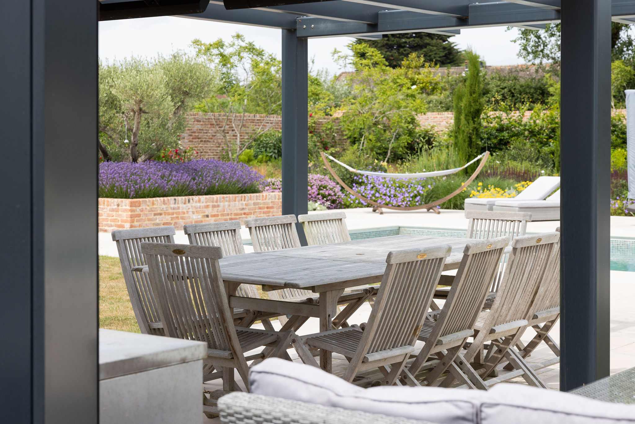 Dine alfresco under the pergola, with views of lavender beds, hammocks, and rolling countryside