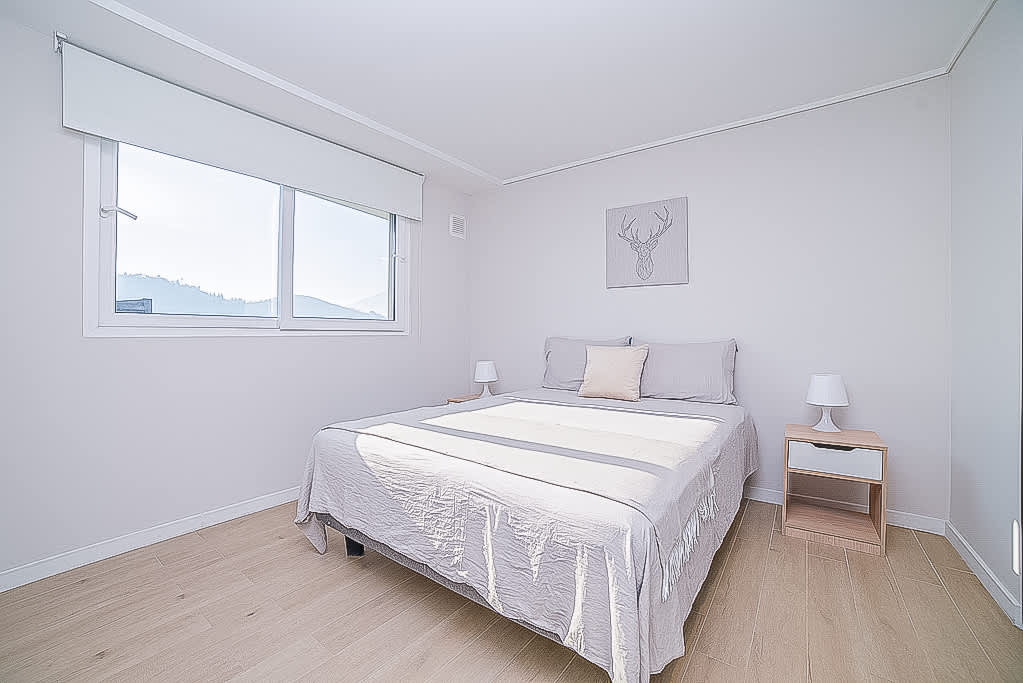 Relax in this serene bedroom with stunning hill views, perfect for a peaceful getaway.