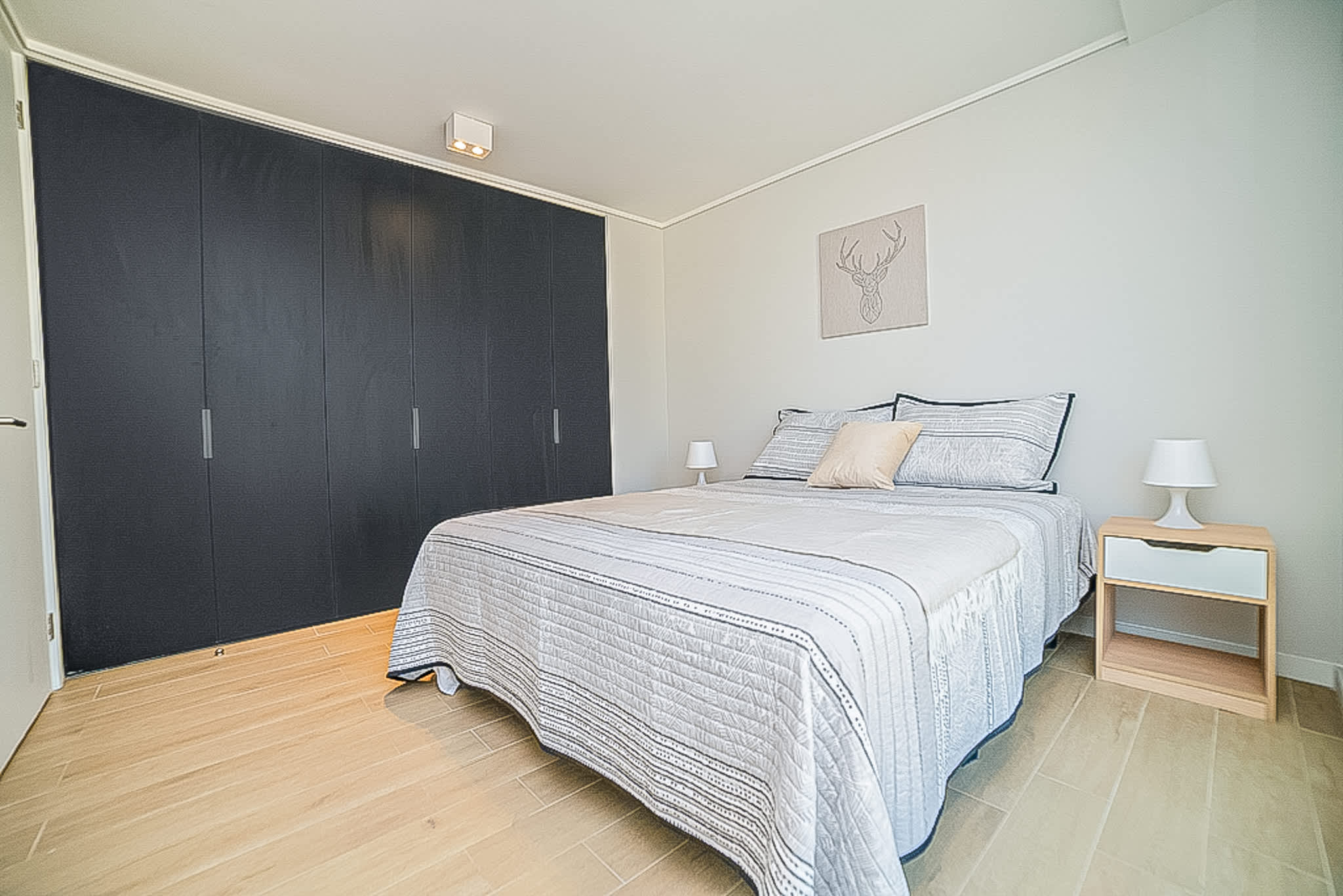 Relax in this cozy bedroom with ample storage and stylish decor, perfect for a restful stay.