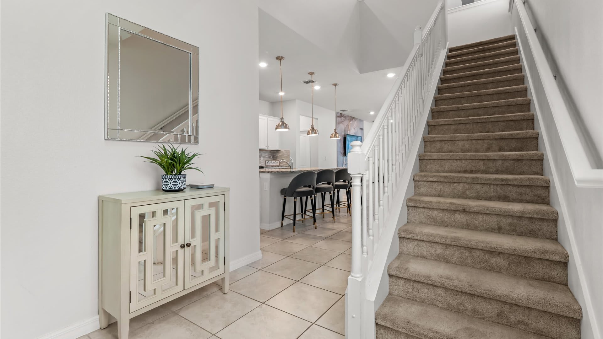 Bright and open staircase connecting the main floor to the themed bedrooms and upstairs lounge.