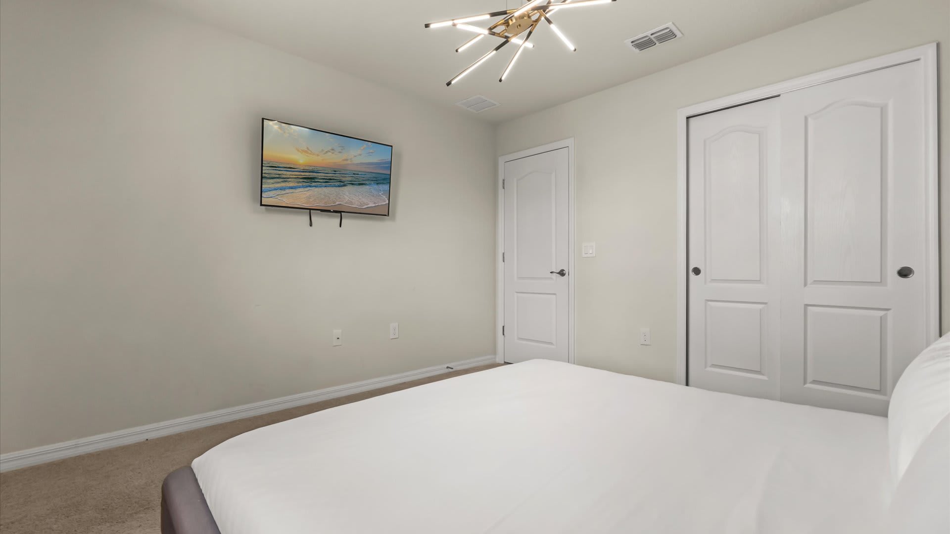Spacious king bedroom with fresh linens, contemporary décor, and easy access to a shared bathroom.