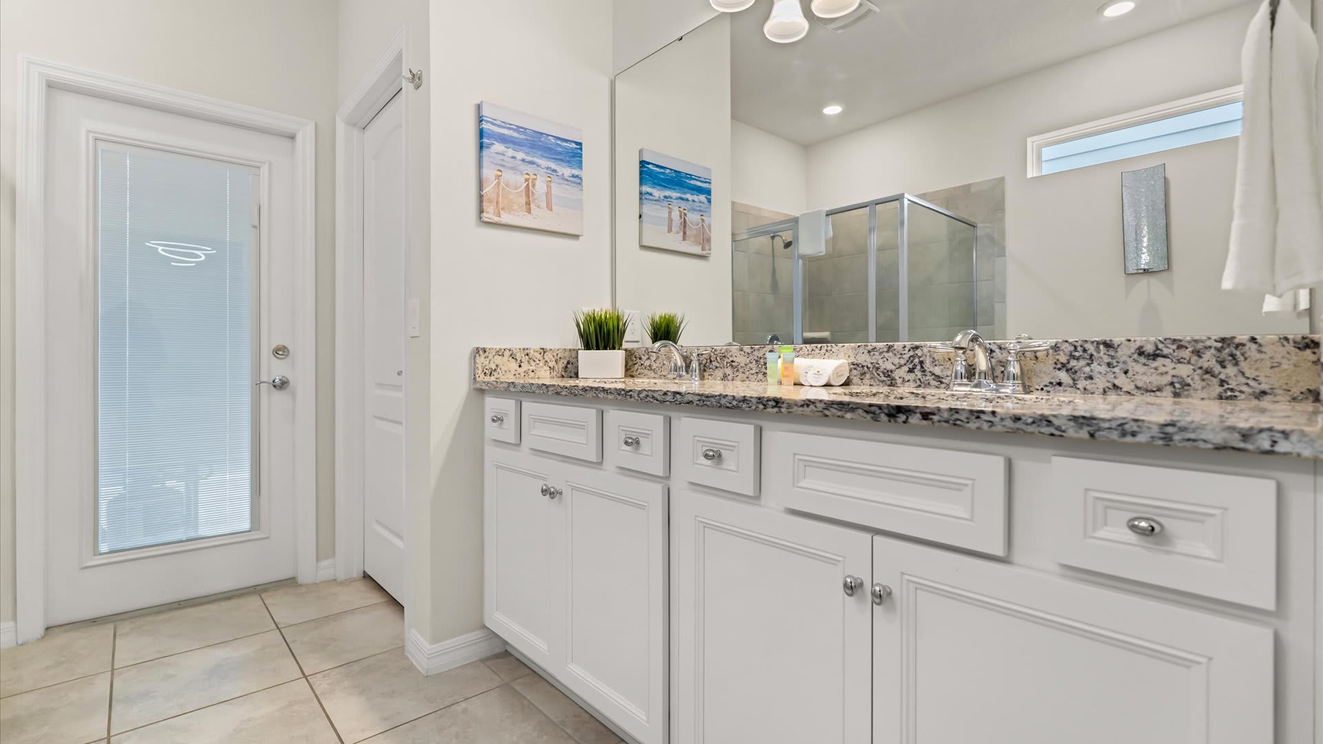 Luxurious bathroom with dual sinks, a glass walk-in shower, and a separate soaking tub. Stocked with fresh towels and hotel-quality toiletries.