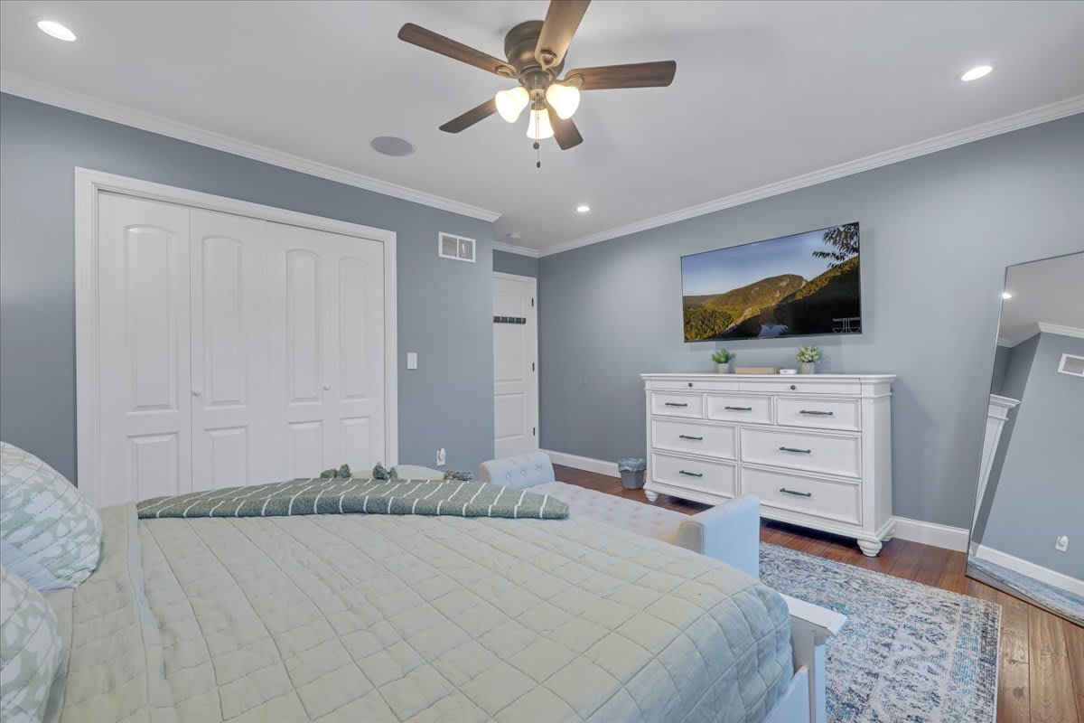 Charming King Bedroom with Exposed Wood Beam Ceiling and Rustic Dresser