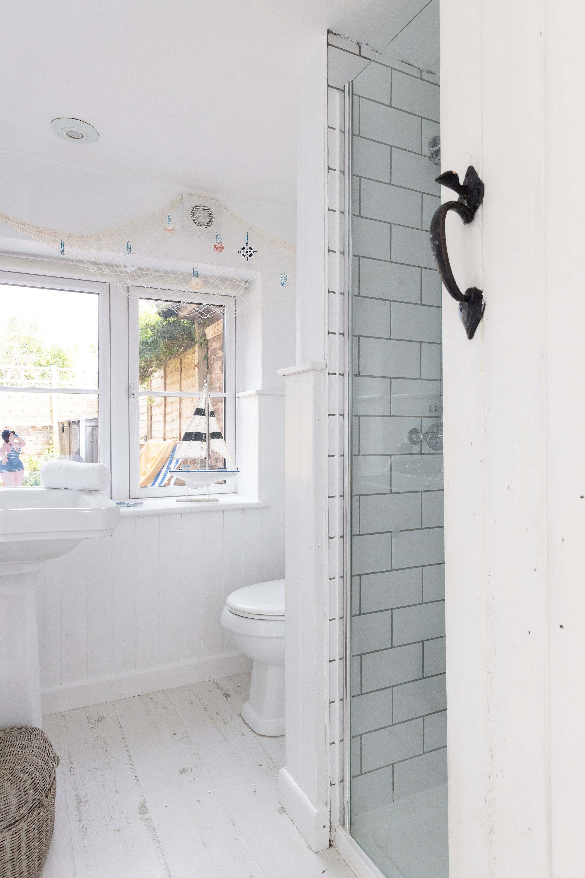 The bathroom has a walk in shower, sink and WC.