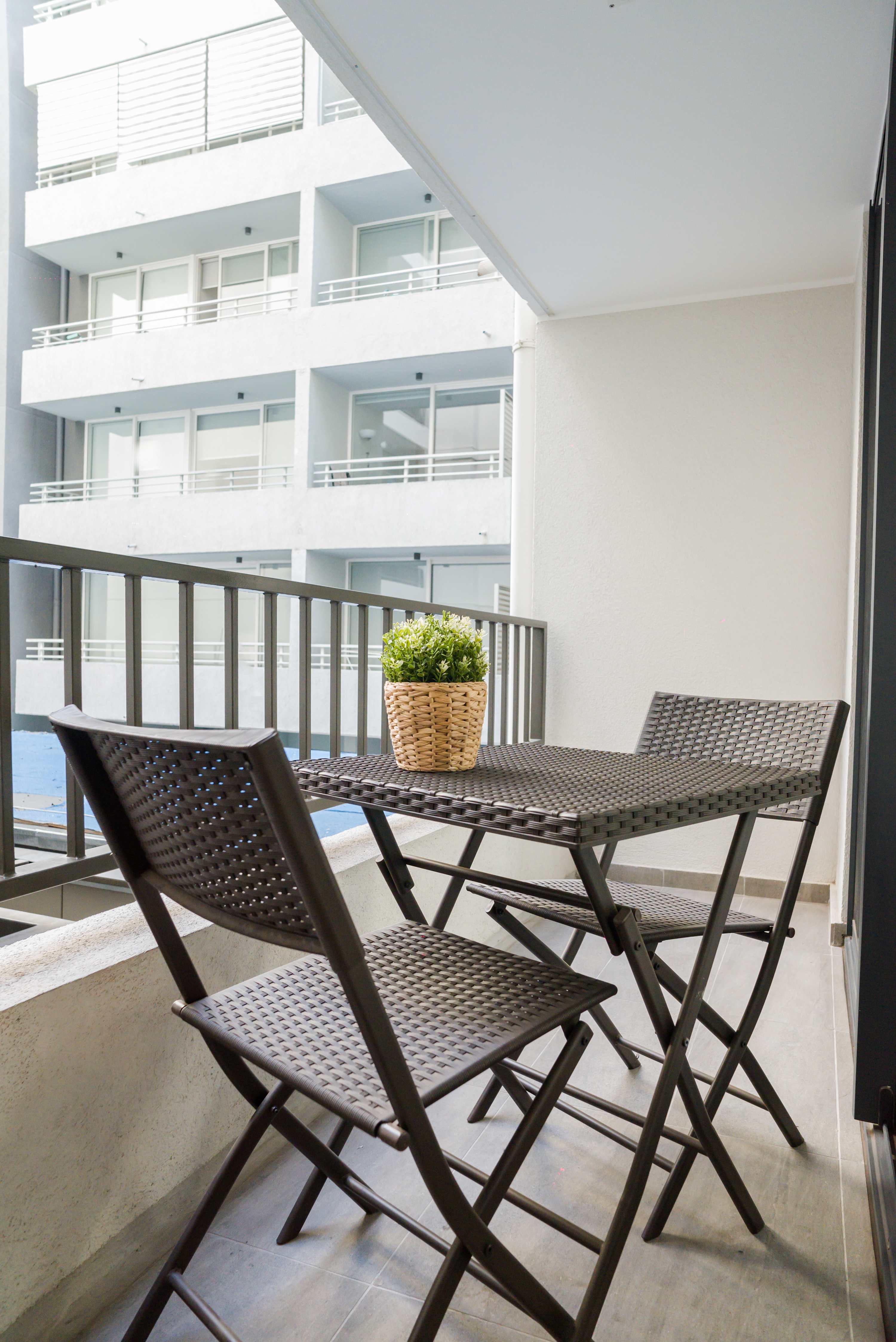 Enjoy a cozy morning coffee on your private balcony with a charming city view.