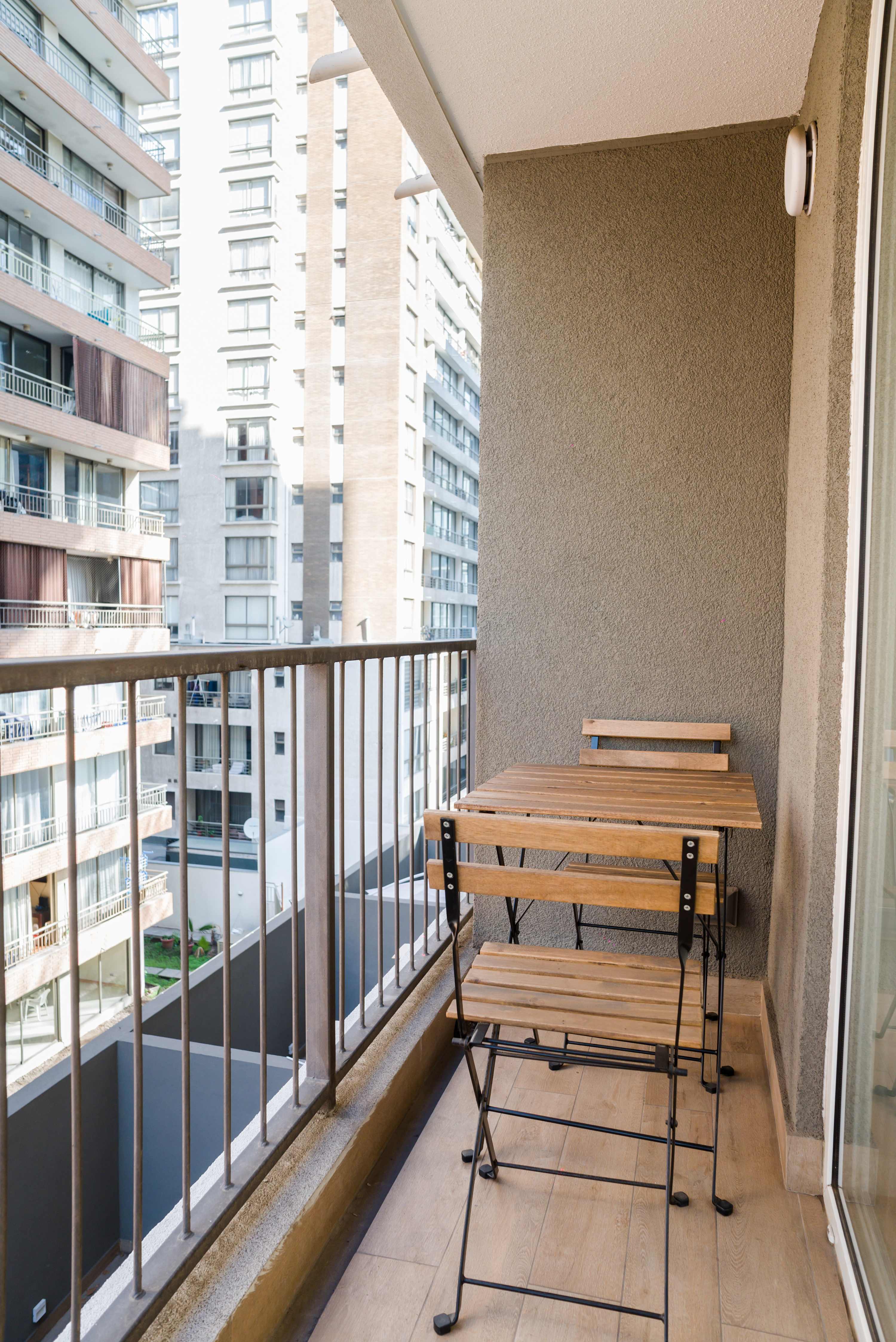 Enjoy your morning coffee on this cozy balcony with city views, perfect for a relaxing start to your day.