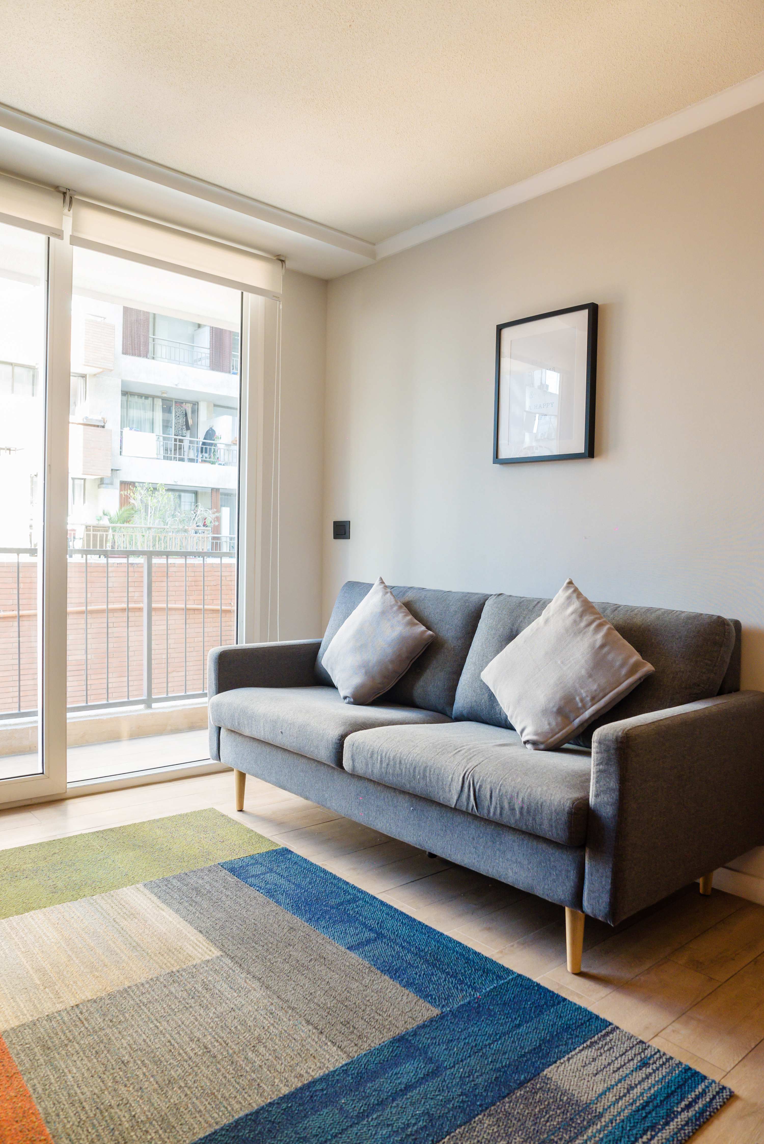 Relax in this cozy living room with a bright balcony view, perfect for unwinding after exploring the city.