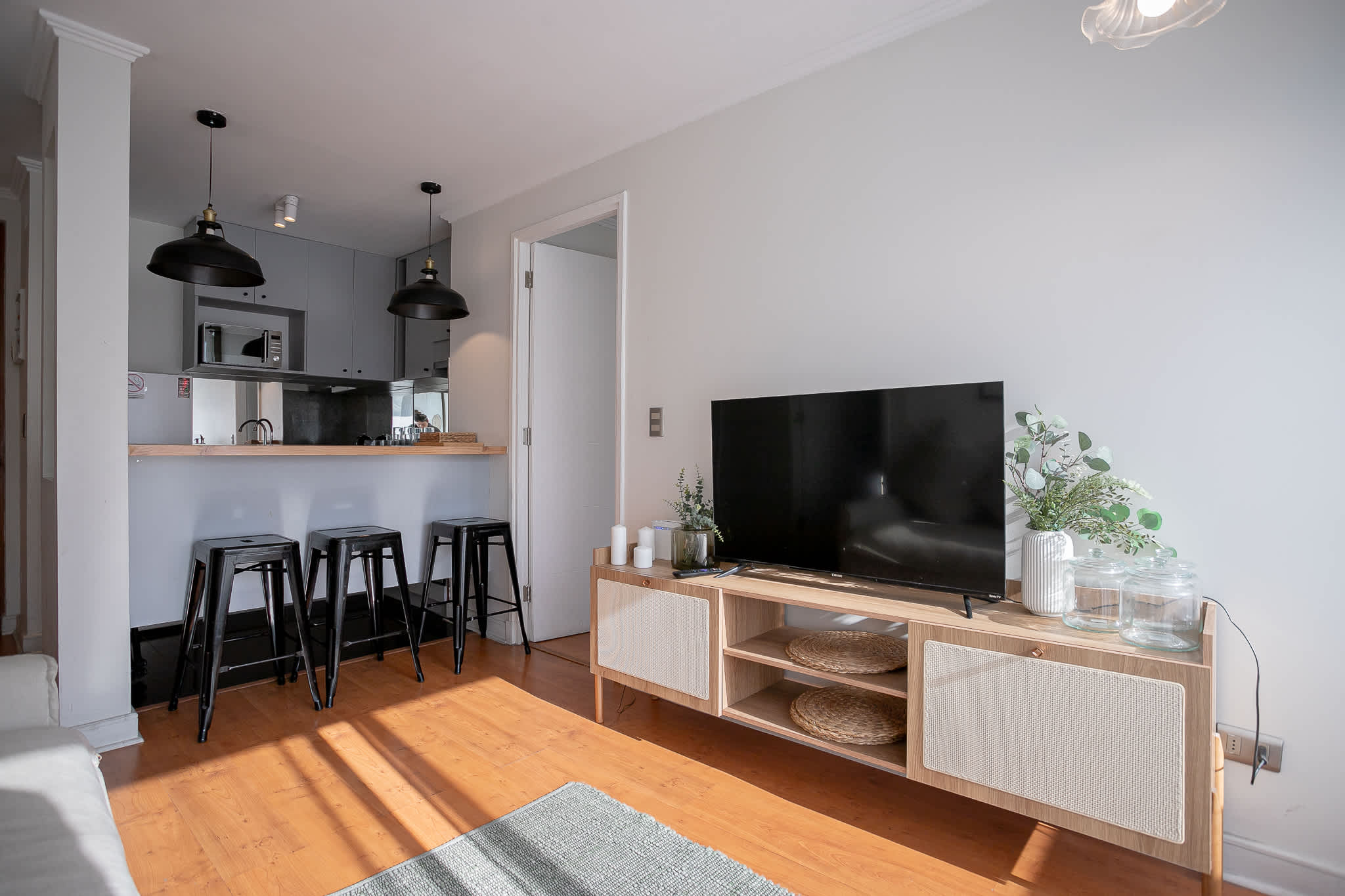 Cozy living area with modern amenities and a stylish kitchen bar, perfect for relaxing or entertaining.