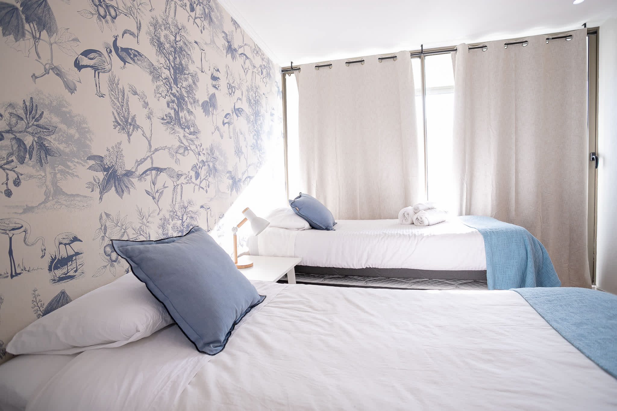 Relax in this charming bedroom with nature-inspired decor and cozy blue accents, perfect for a restful stay.