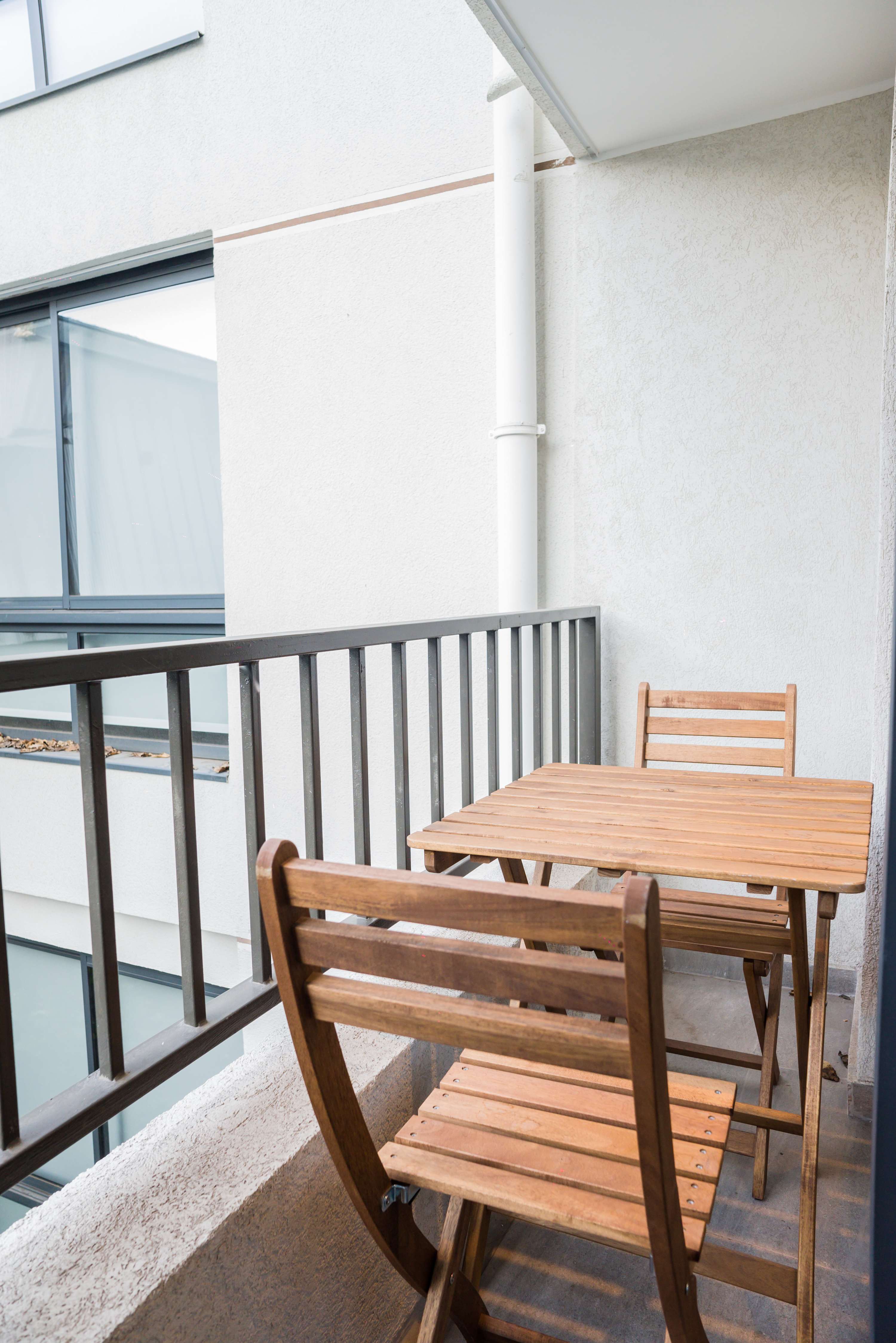 Enjoy a cozy morning coffee on your private balcony with charming wooden seating.