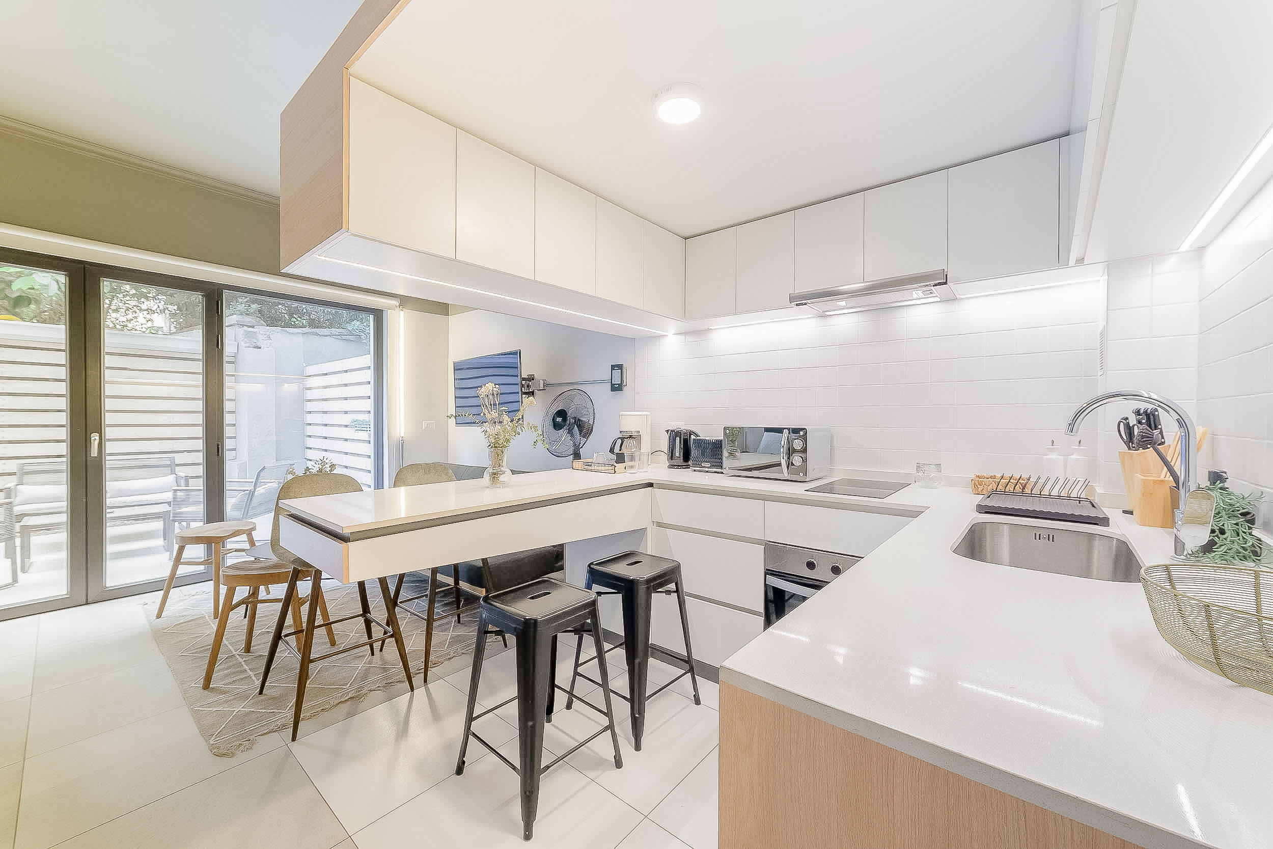 Bright and modern kitchen with sleek appliances and a cozy dining area, perfect for enjoying meals in style.