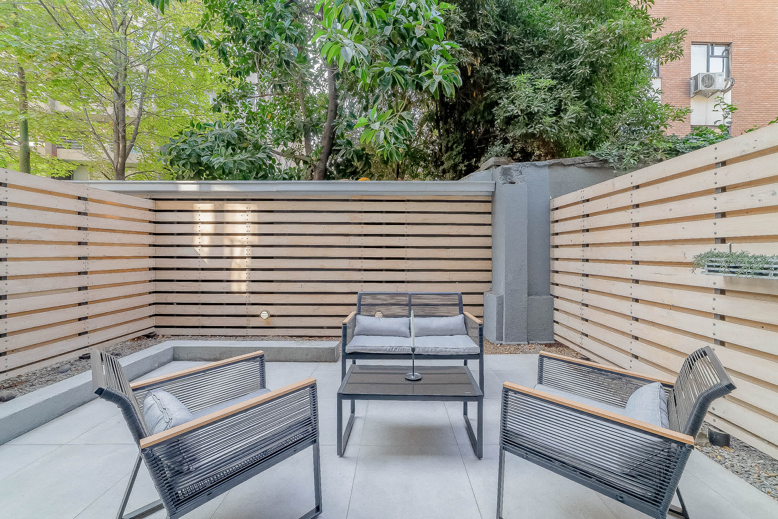 Relax in this serene outdoor patio, perfect for morning coffee or evening unwinding amidst lush greenery.
