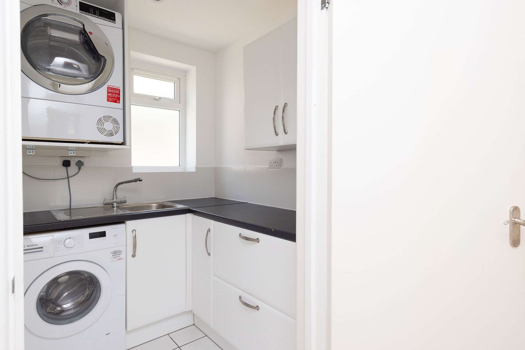 Handy utility space with washing machine, dryer, sink and storage