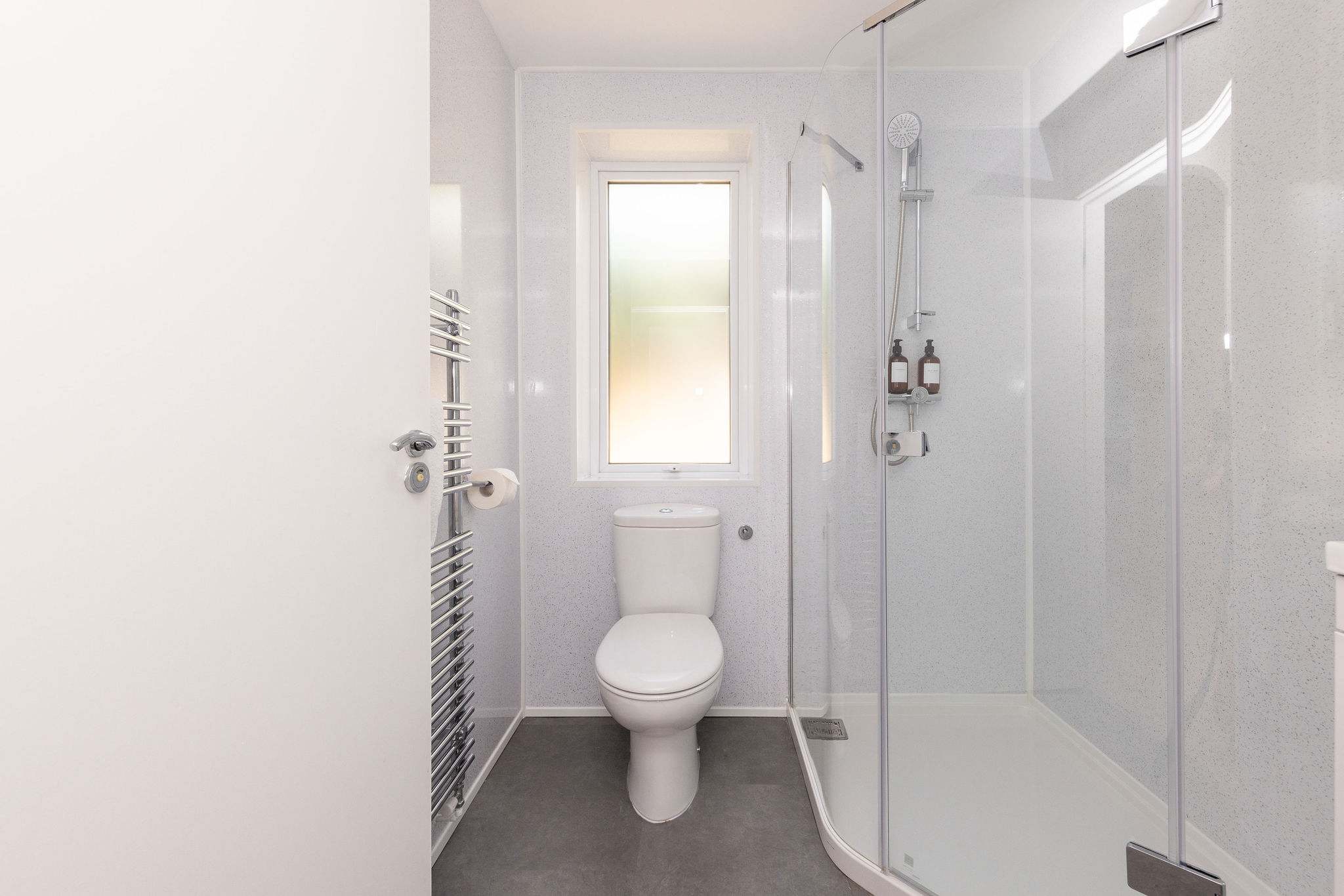 Modern shower room with heated towel rail and window