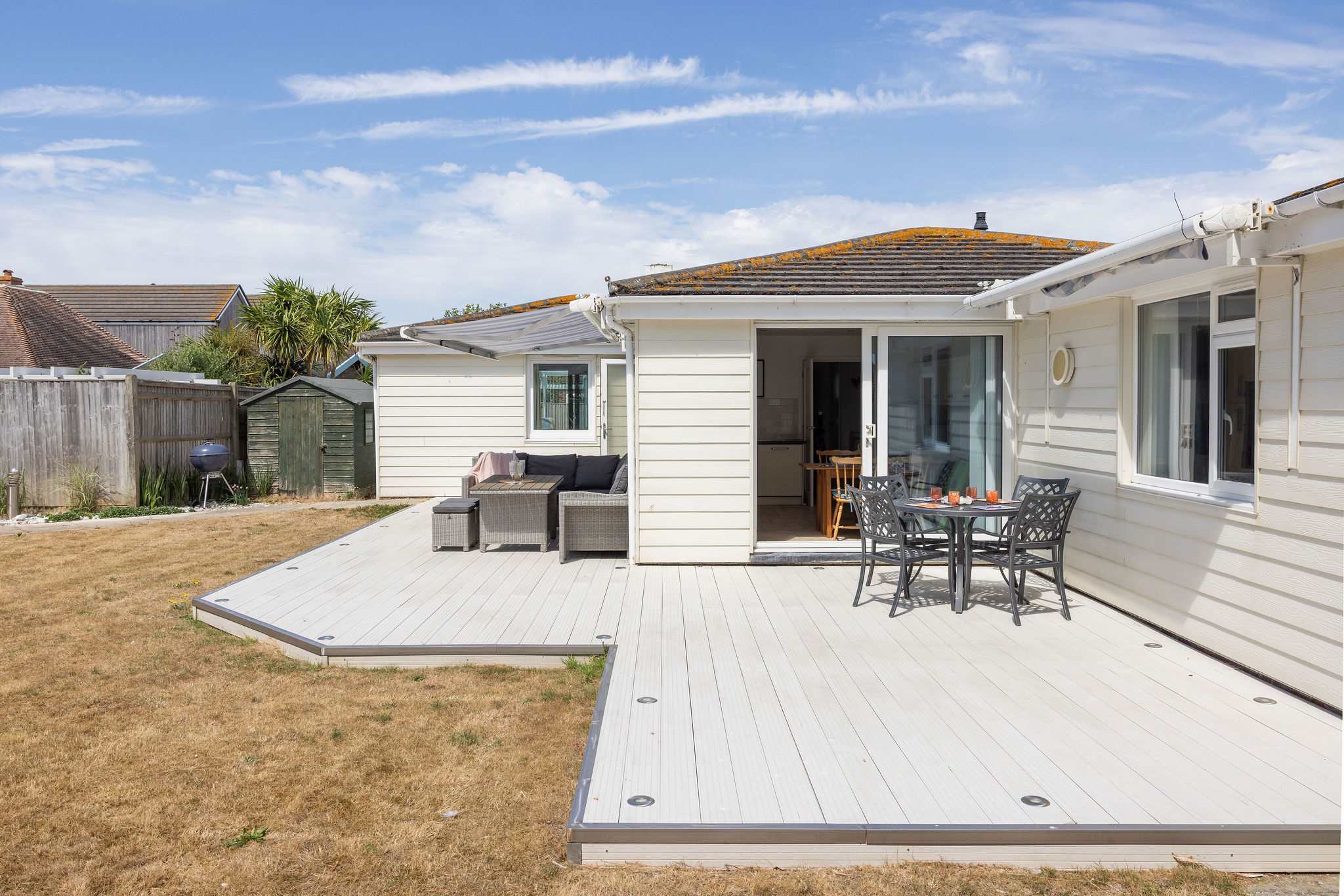 Large wraparound decking with outdoor dining and lounge areas