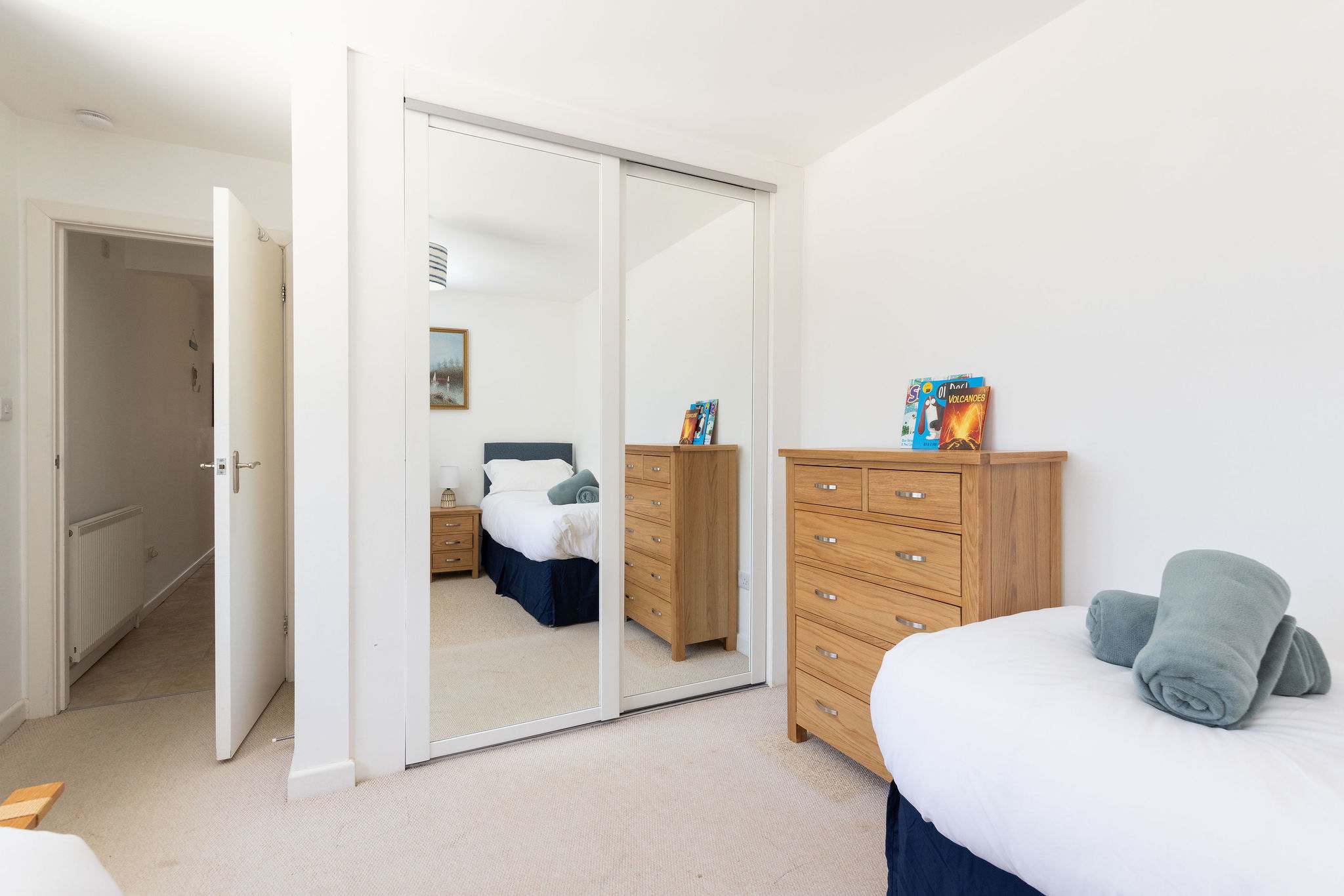 Spacious twin room with mirrored wardrobe and chest of drawers
