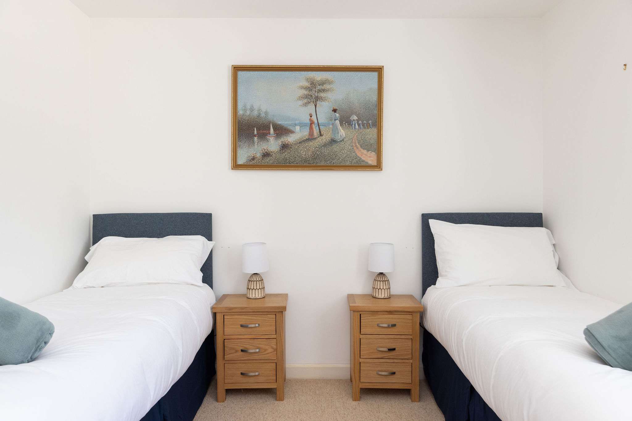 Twin bedroom with matching side tables and soft lighting