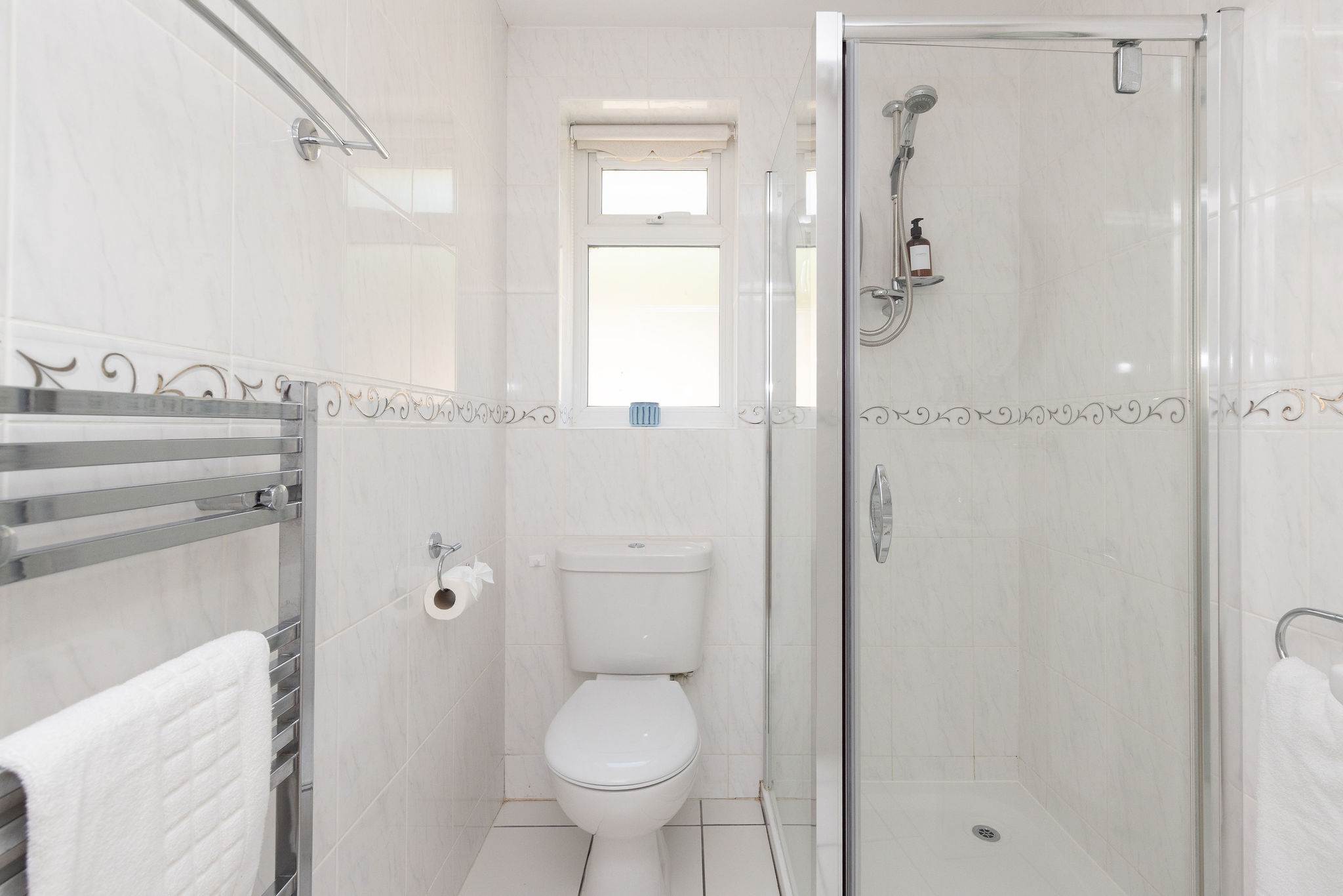 Bright en-suite with walk-in shower and classic tiling