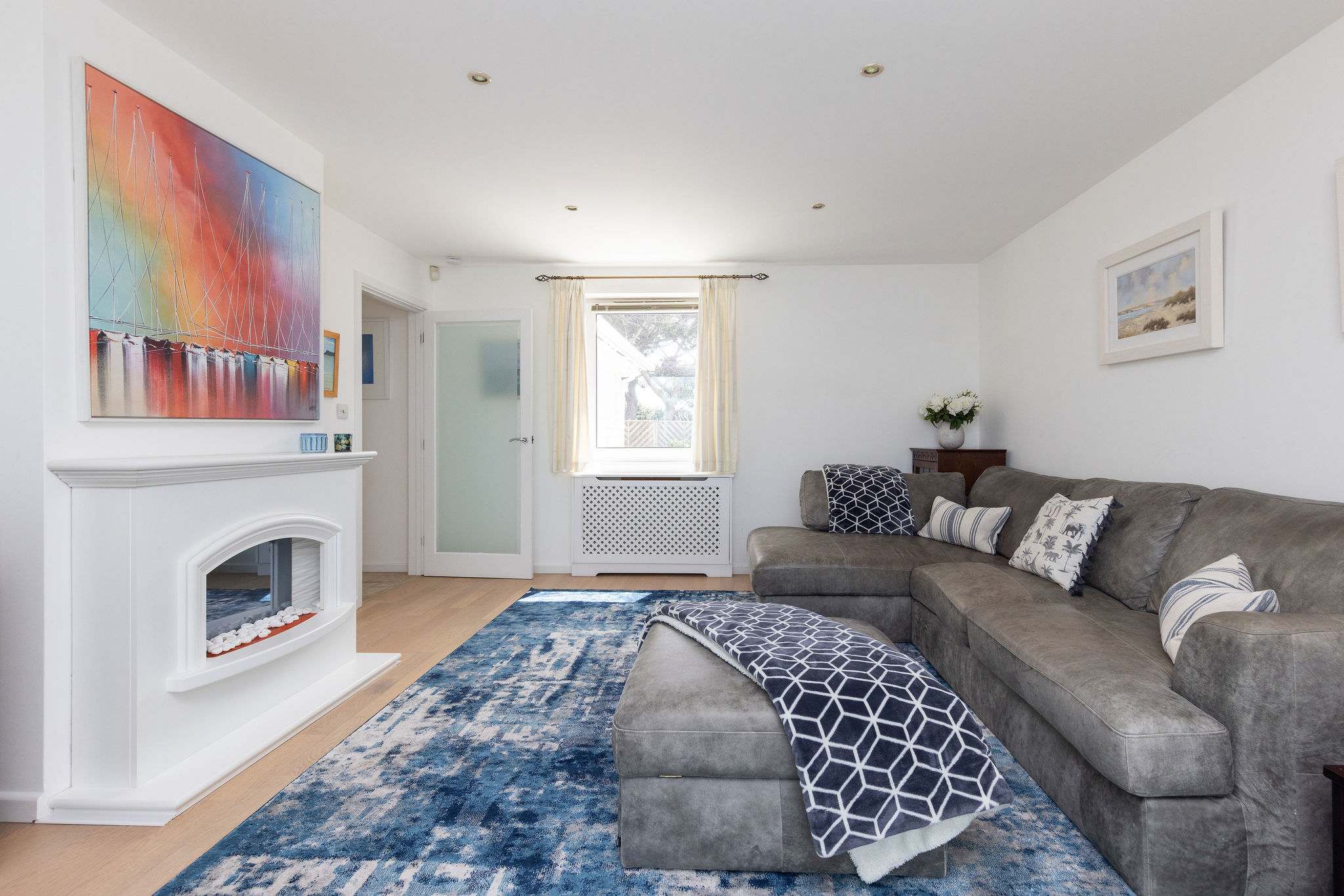 Cosy lounge with plush corner sofa and calming coastal décor.