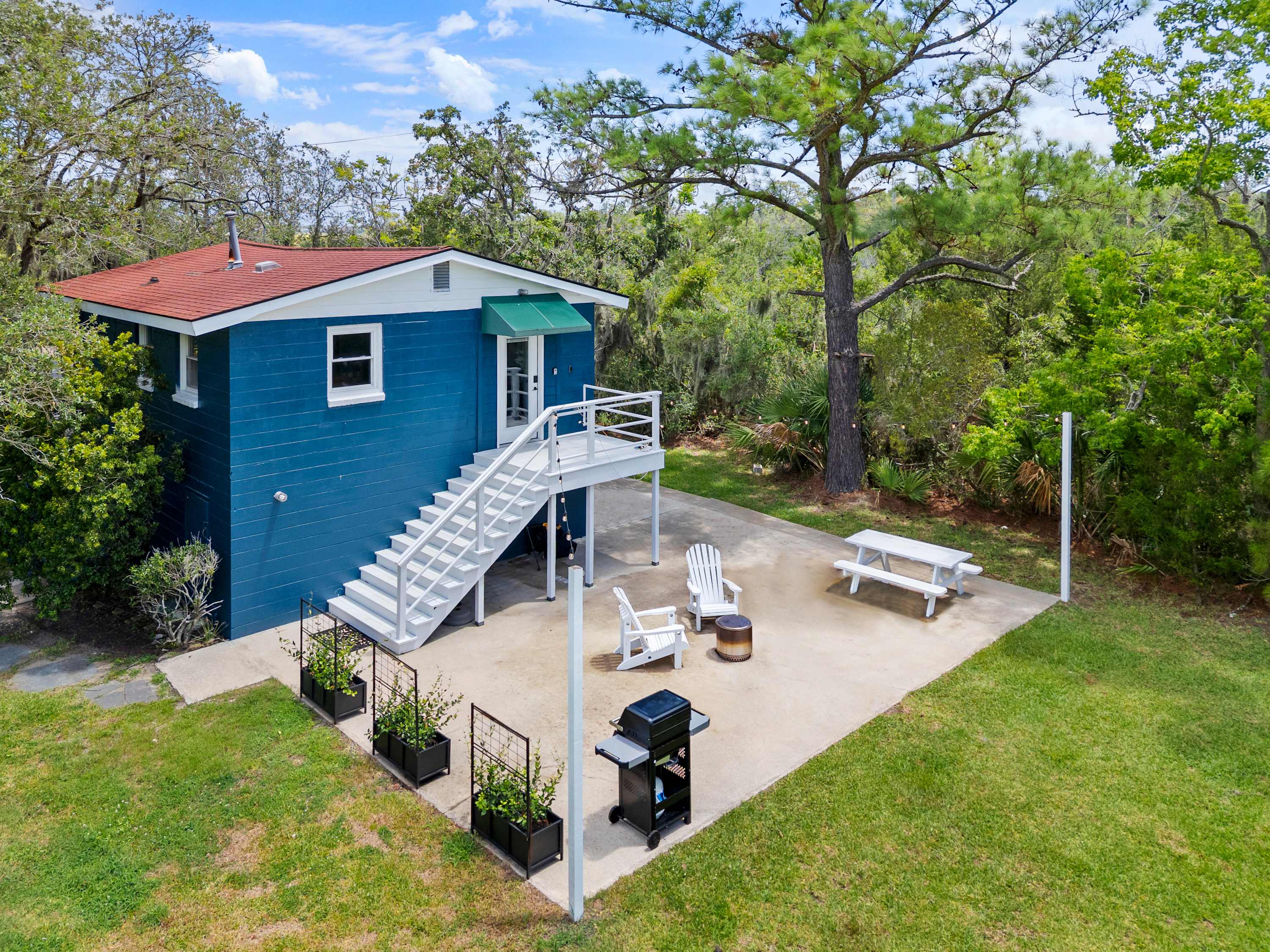 Exterior of the rental with a private back patio with plenty of seating and a grill!
