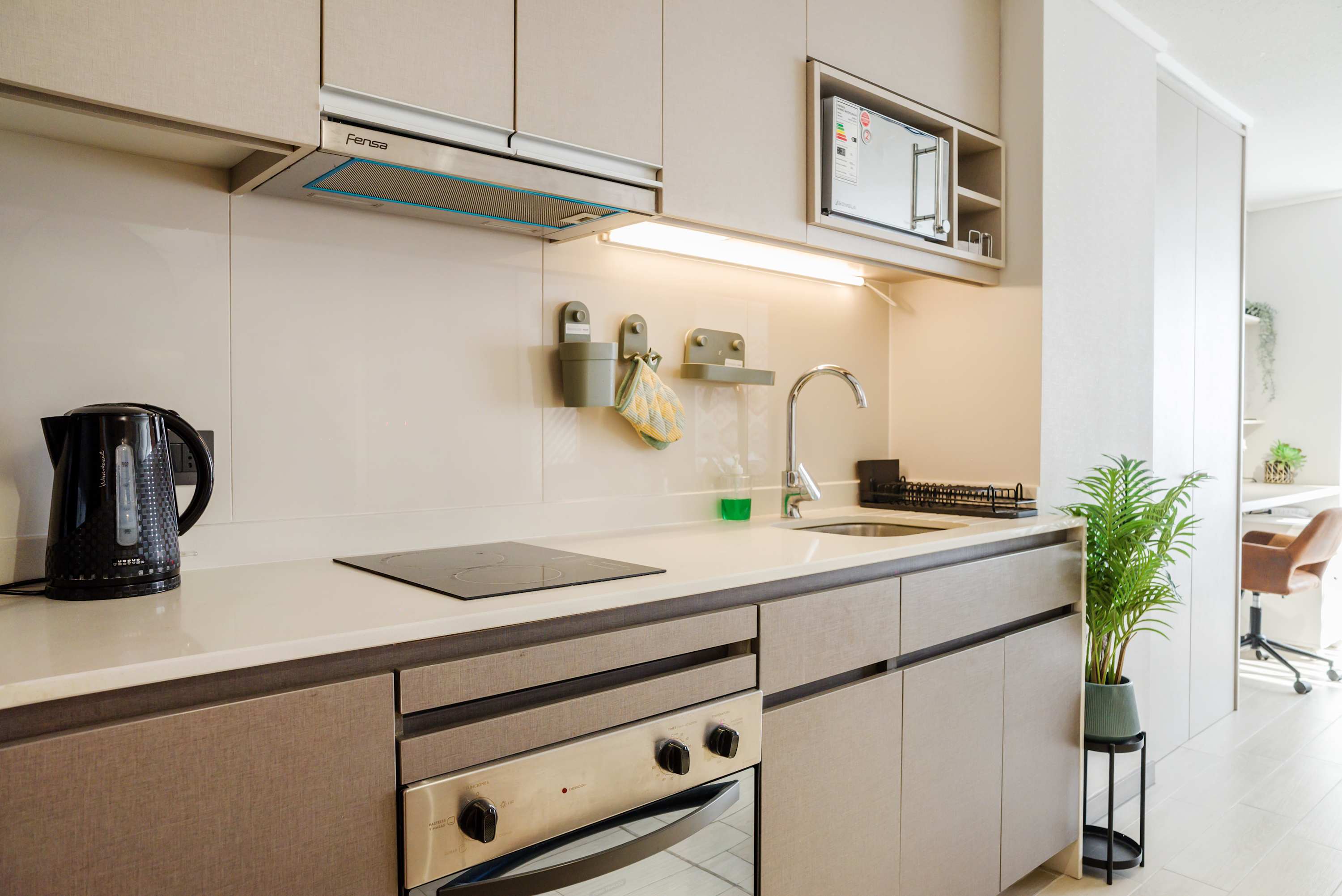 Modern kitchen with sleek appliances and stylish decor, perfect for a cozy stay in Chile.