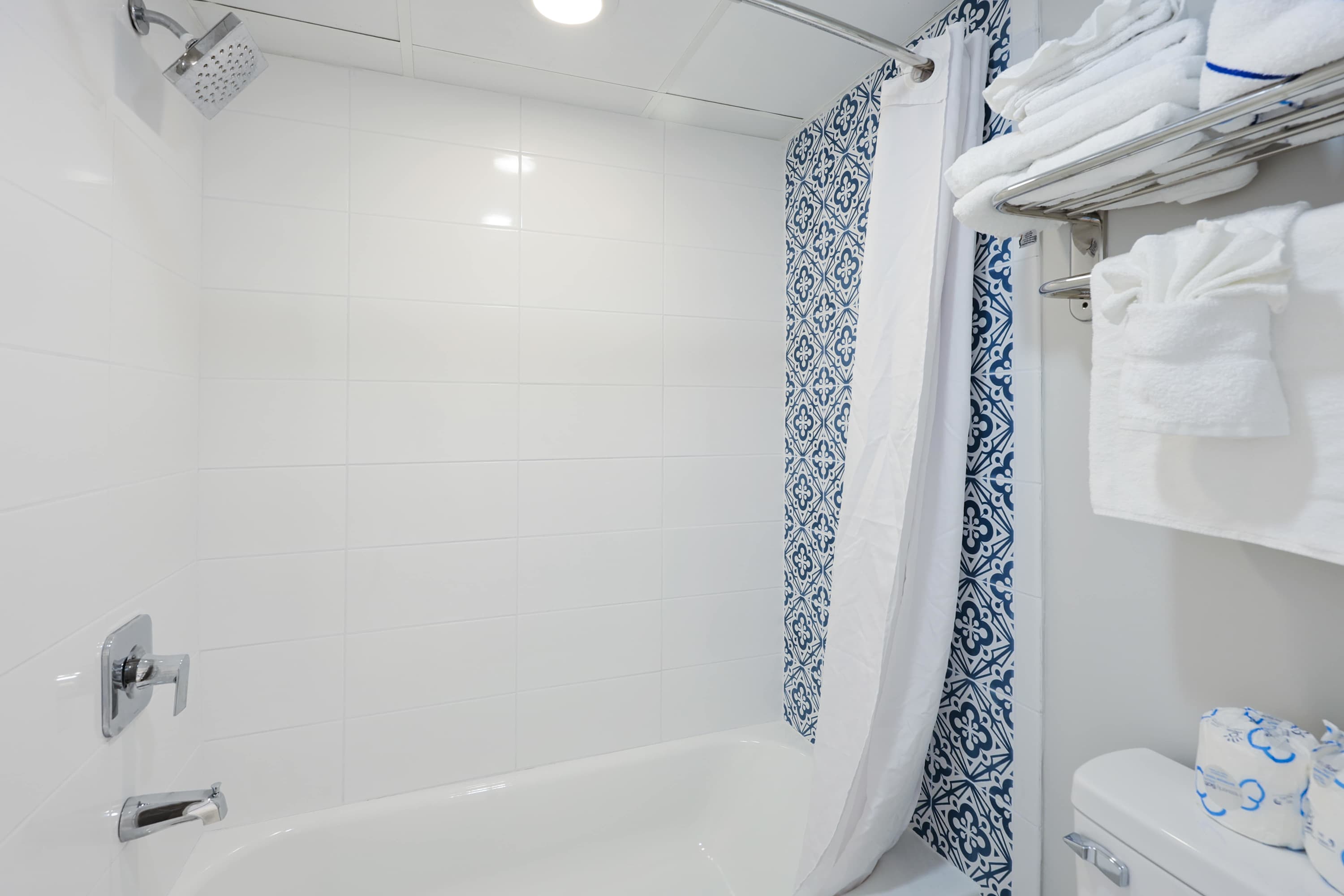 Unwind with a soothing soak in this spotless tub-and-shower combo, featuring spa-inspired tile accents and plush hotel-style towels—your private retreat after a sun-filled beach day.
