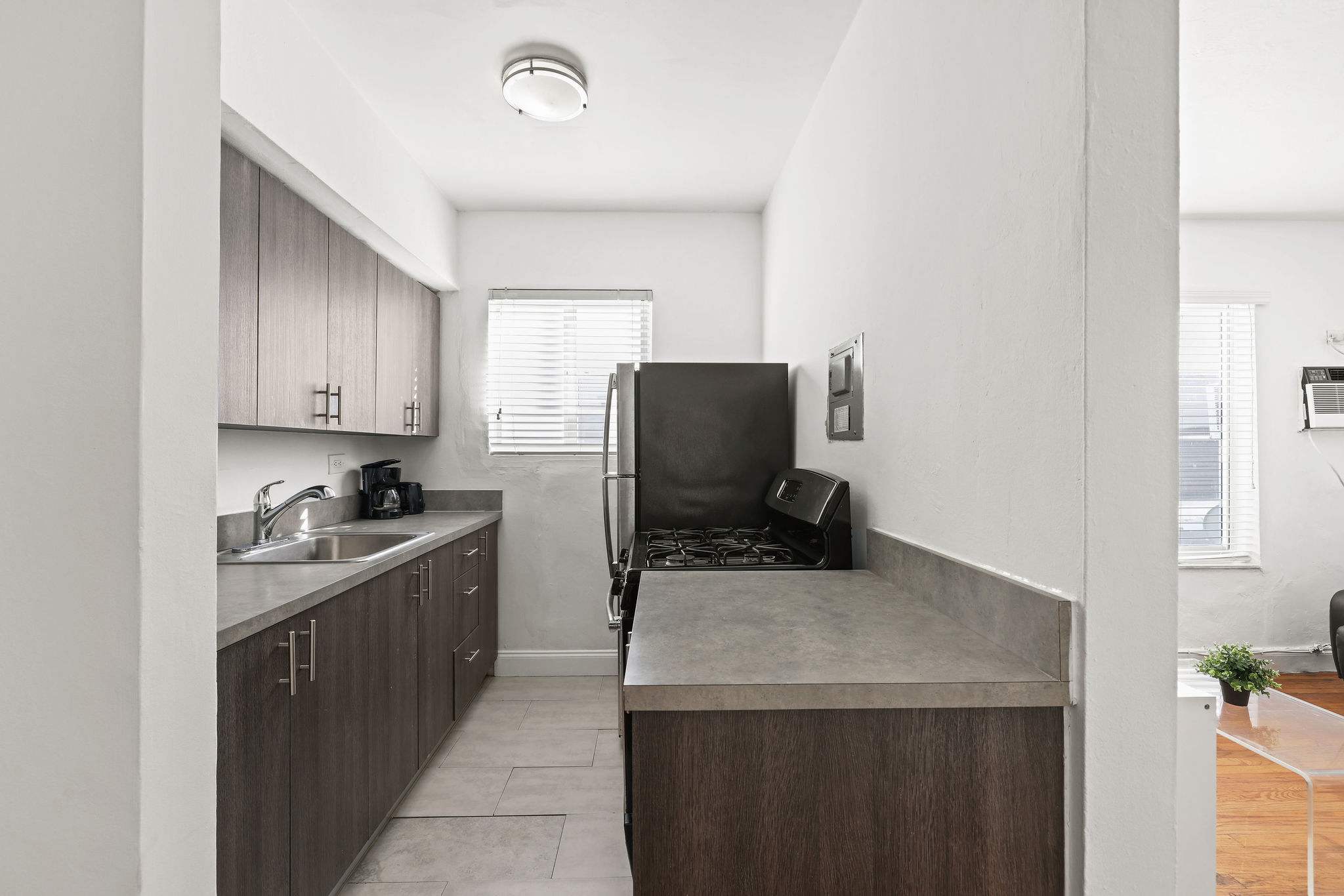 Modern kitchen with sleek cabinetry and stainless steel appliances, perfect for preparing meals in a cozy studio setting.