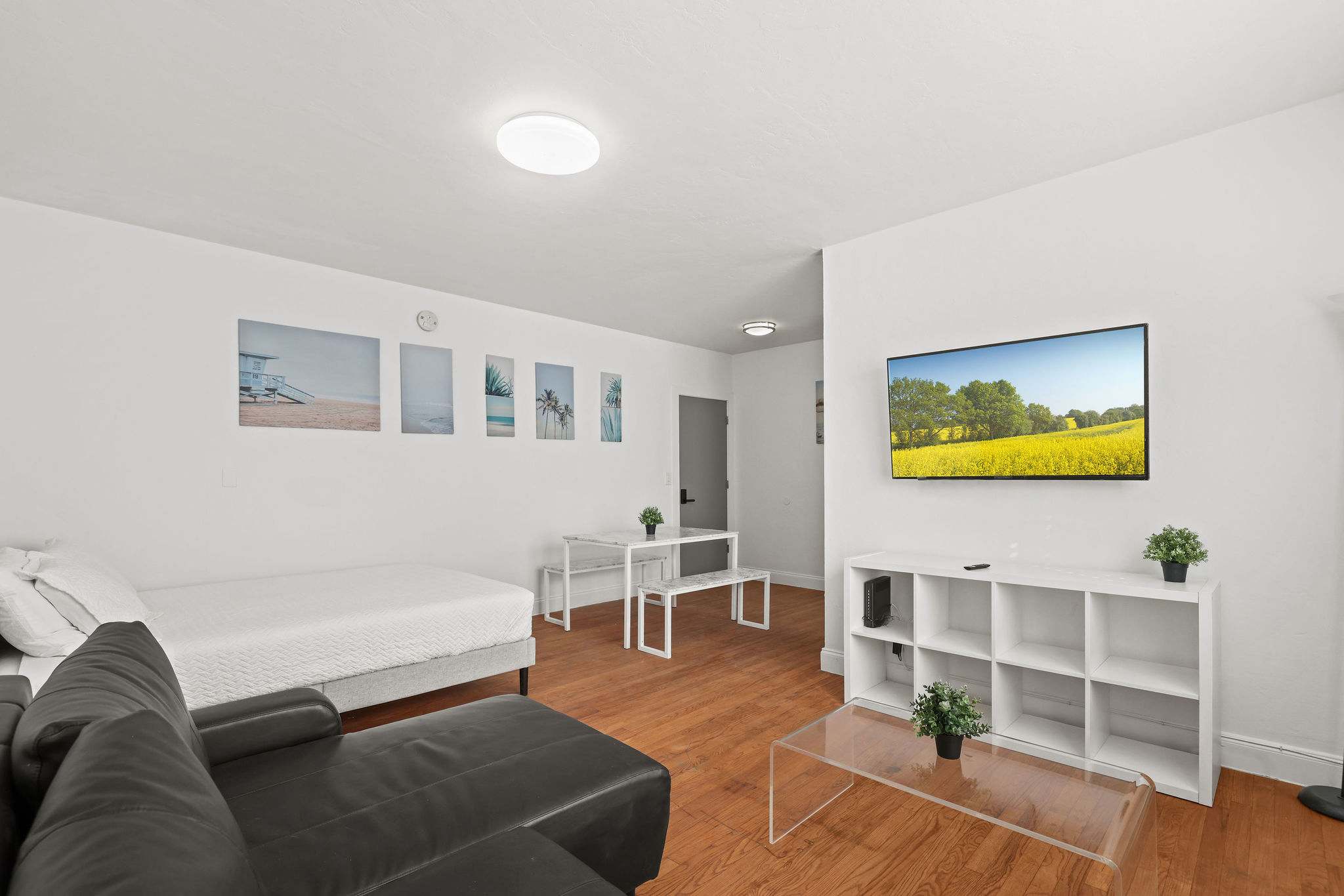 Cozy studio with modern decor, perfect for a relaxing stay. Enjoy the comfort of a plush sofa and a wall-mounted TV for entertainment.