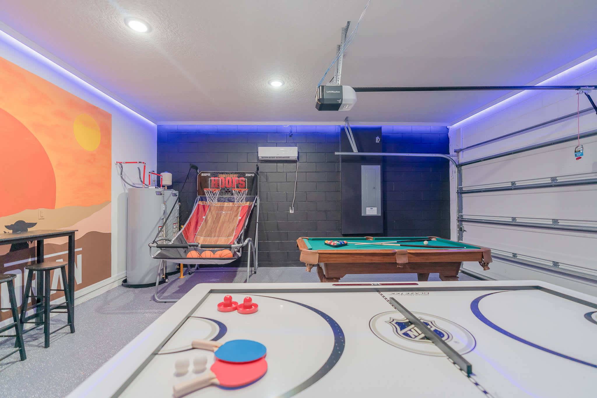 Unleash your competitive spirit in this vibrant game room with basketball, pool, and air hockey. Perfect for family fun!