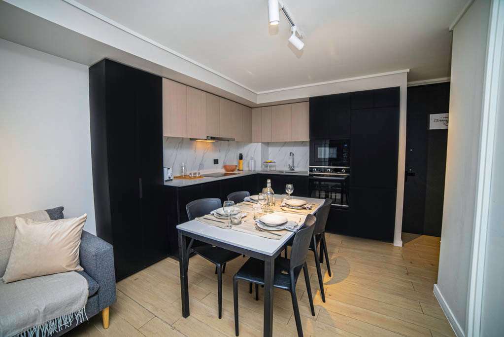 Stylish kitchen and dining area in a cozy studio apartment, perfect for intimate meals and relaxation.