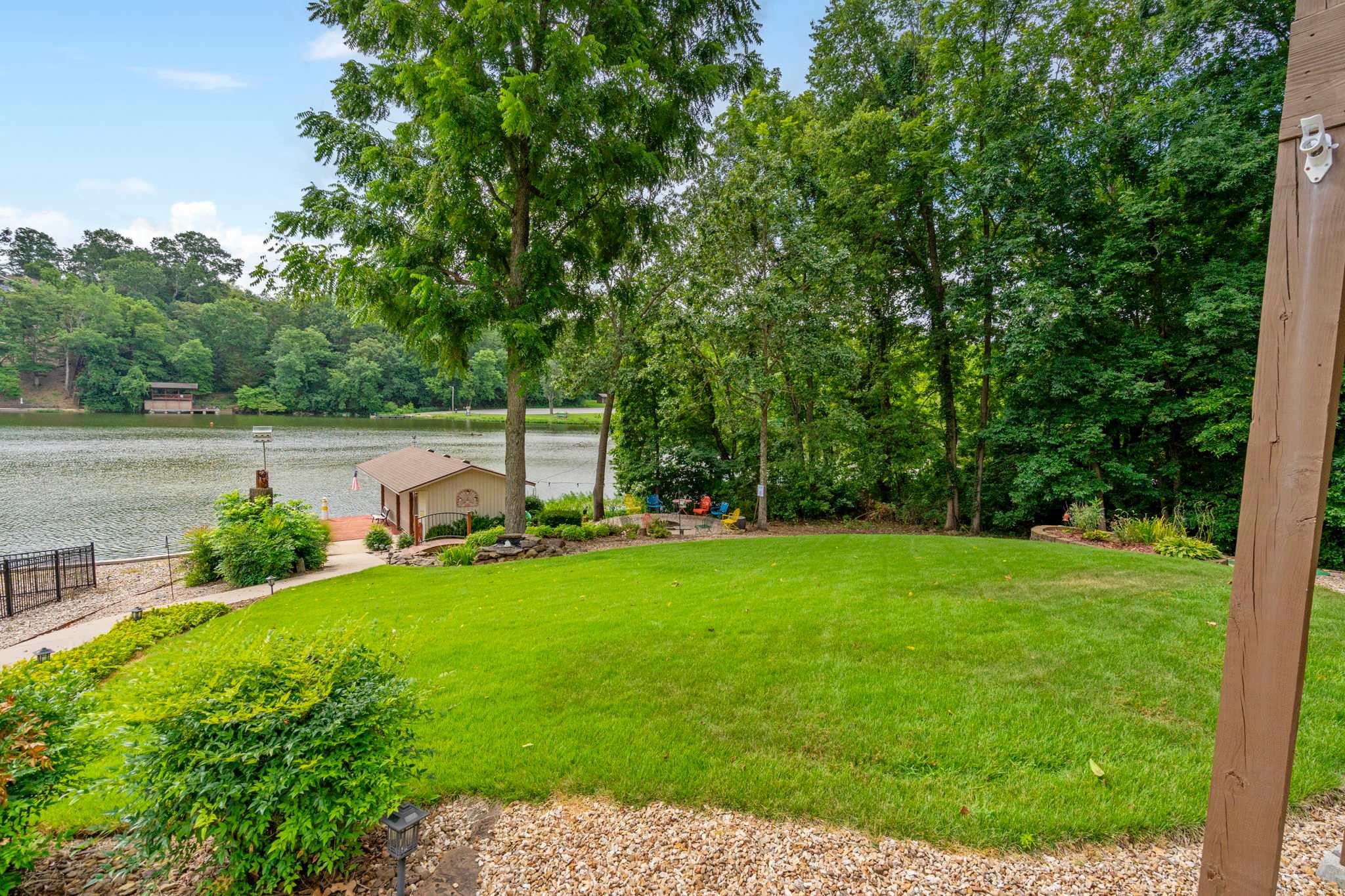 lush yard leading to boat house, dock, and fire pit