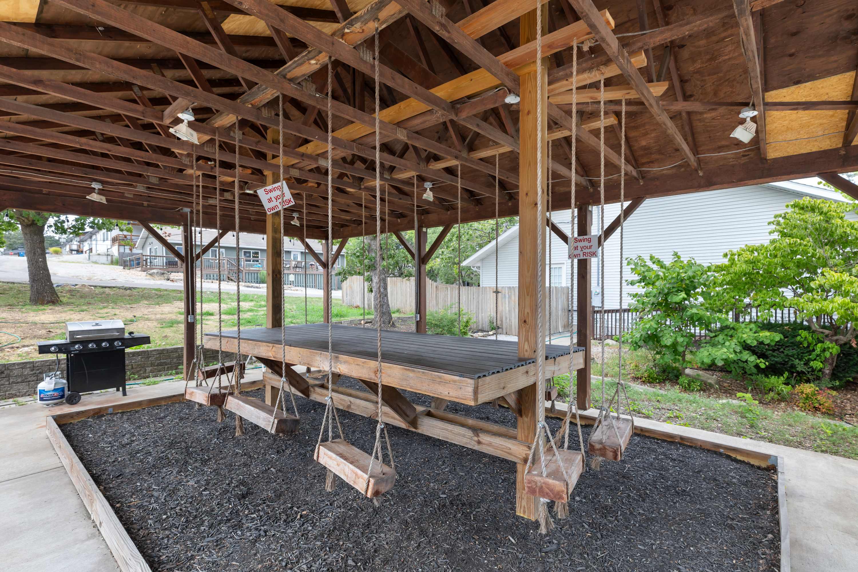 Unique shared grill area with a table and swinging chairs.