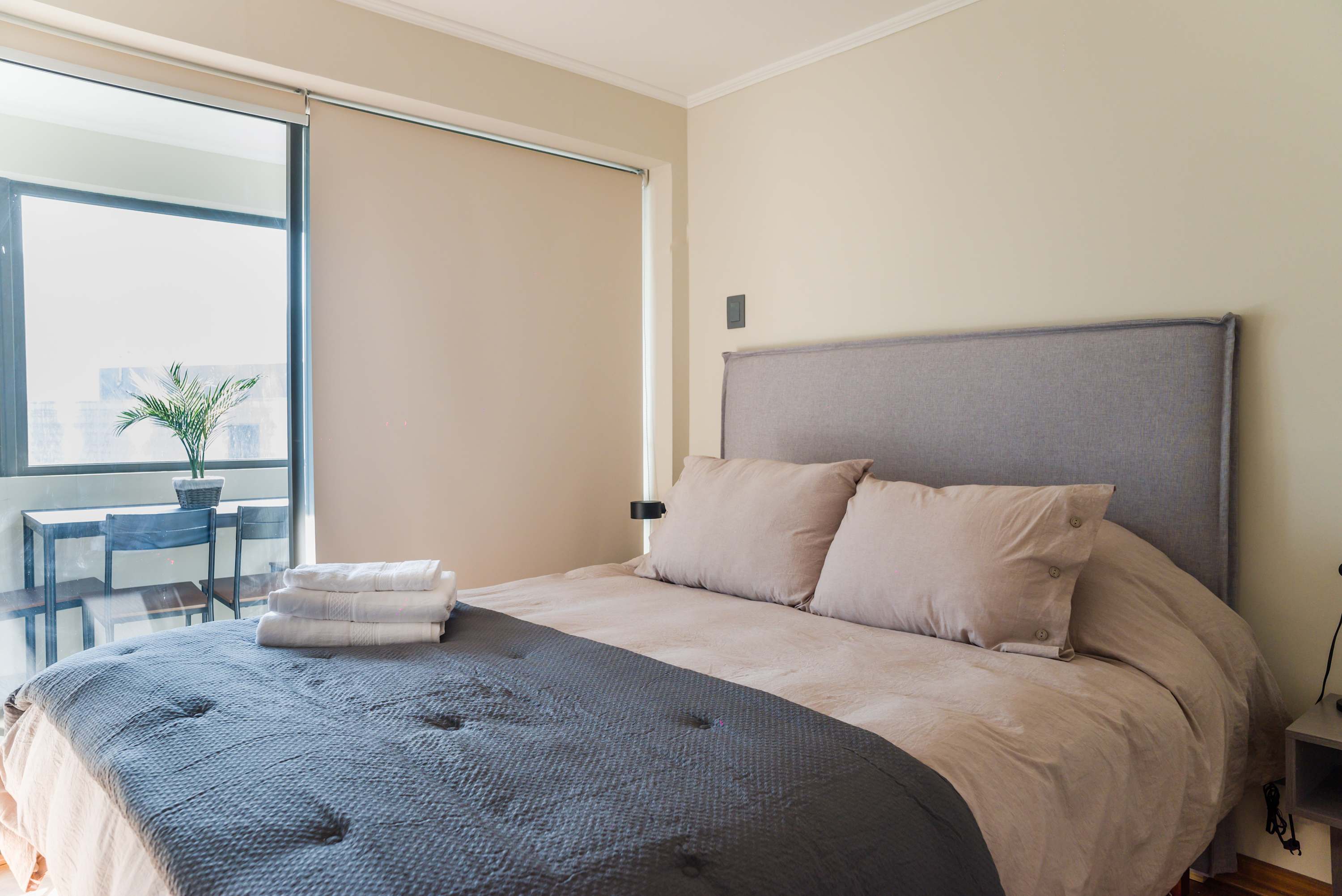 Relax in this cozy bedroom with natural light and a serene view, perfect for unwinding after a day exploring the city.