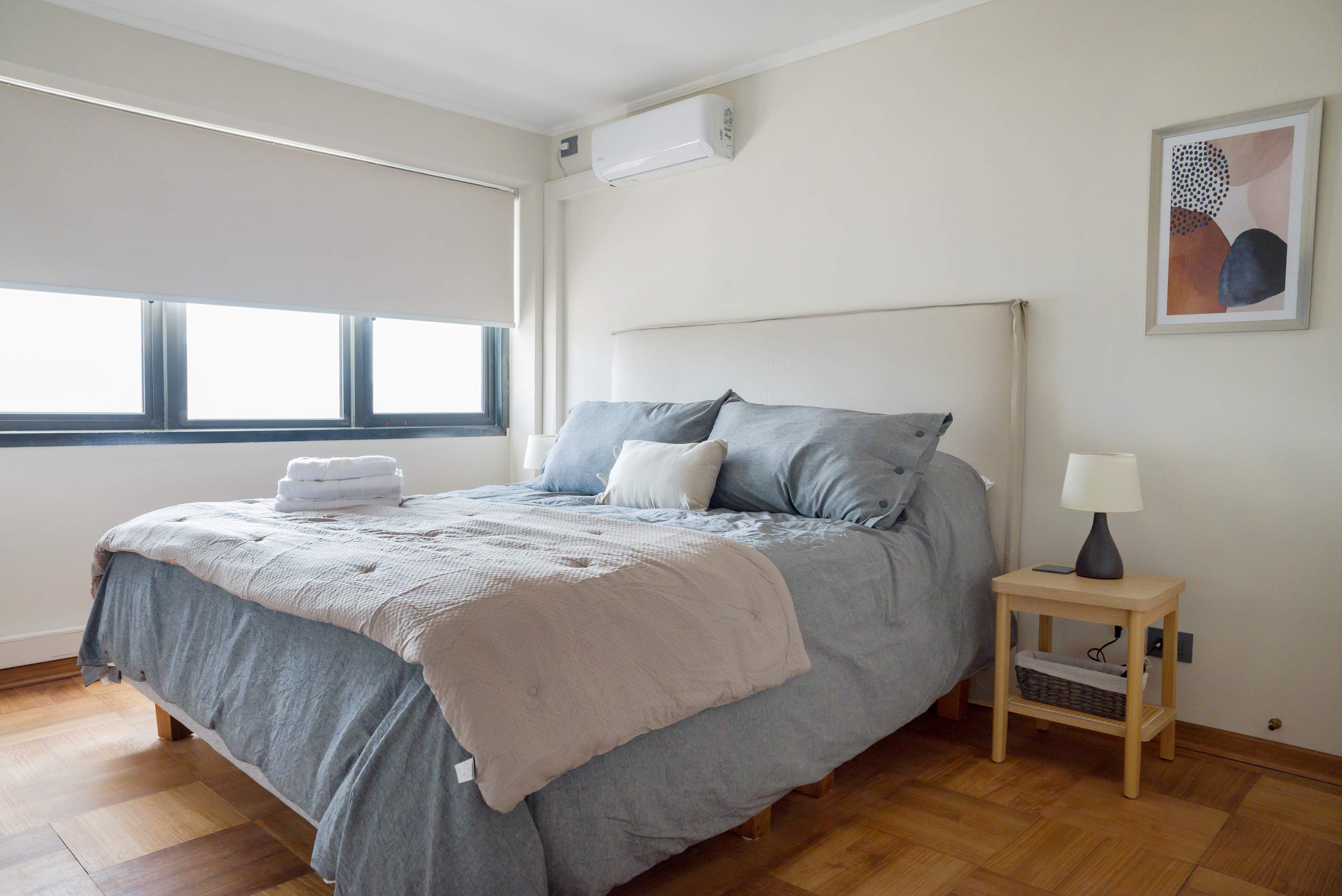 Relax in this cozy bedroom with plush bedding and modern decor, perfect for a restful stay.