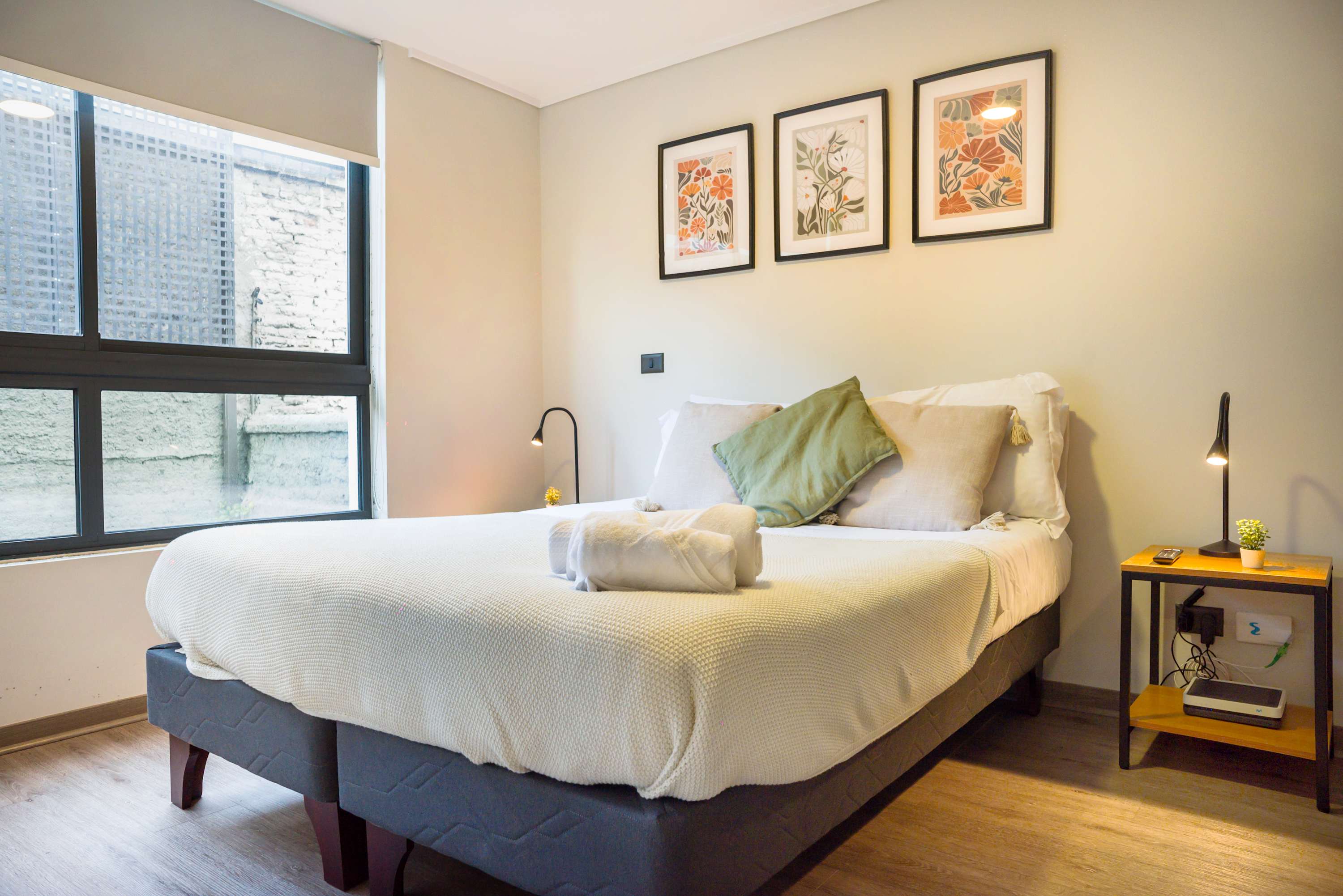Relax in this cozy bedroom with natural light and stylish decor, perfect for a restful stay.