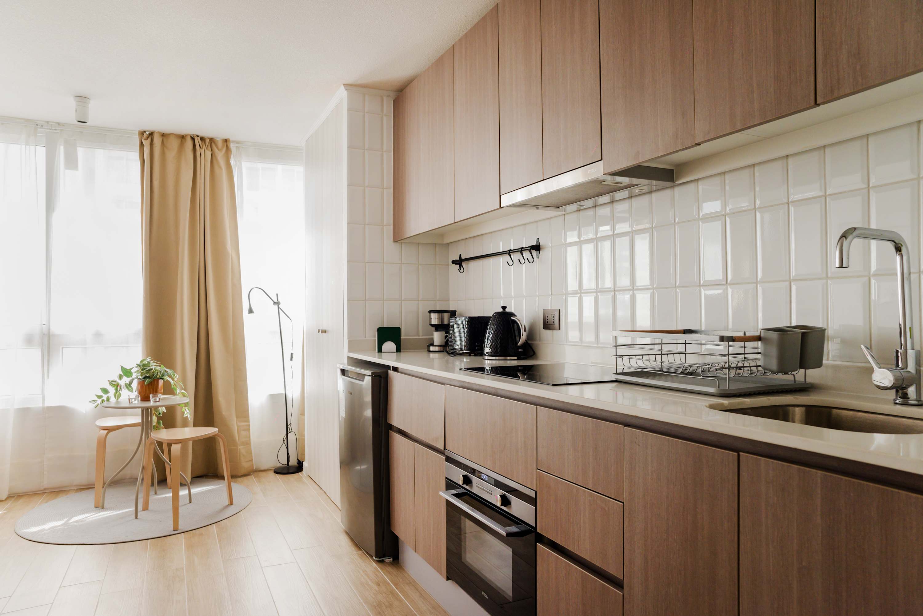 Cozy and modern kitchen with natural light and a charming dining nook, perfect for a relaxing meal.
