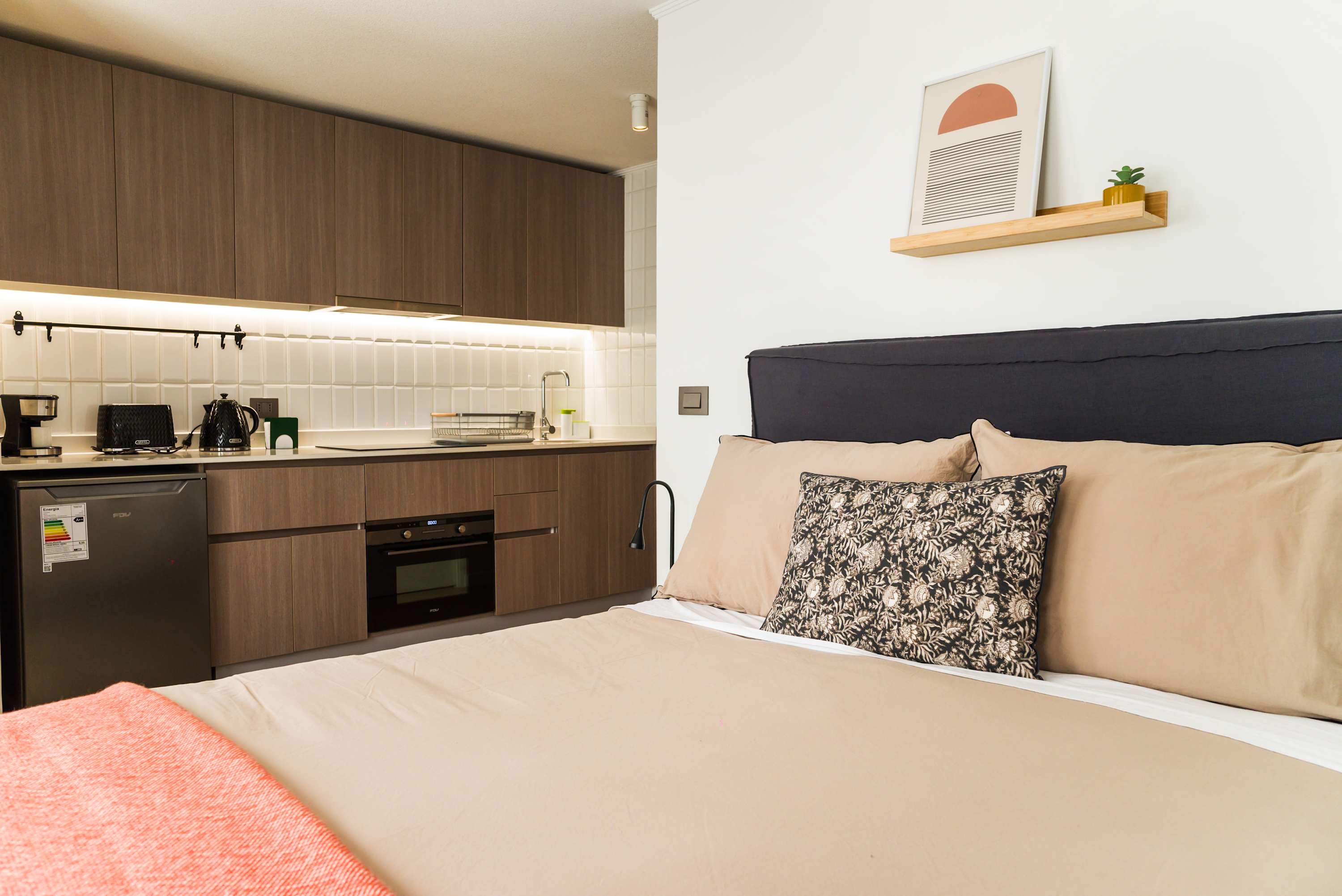 Modern studio with a sleek kitchen and cozy sleeping area, perfect for a comfortable stay.
